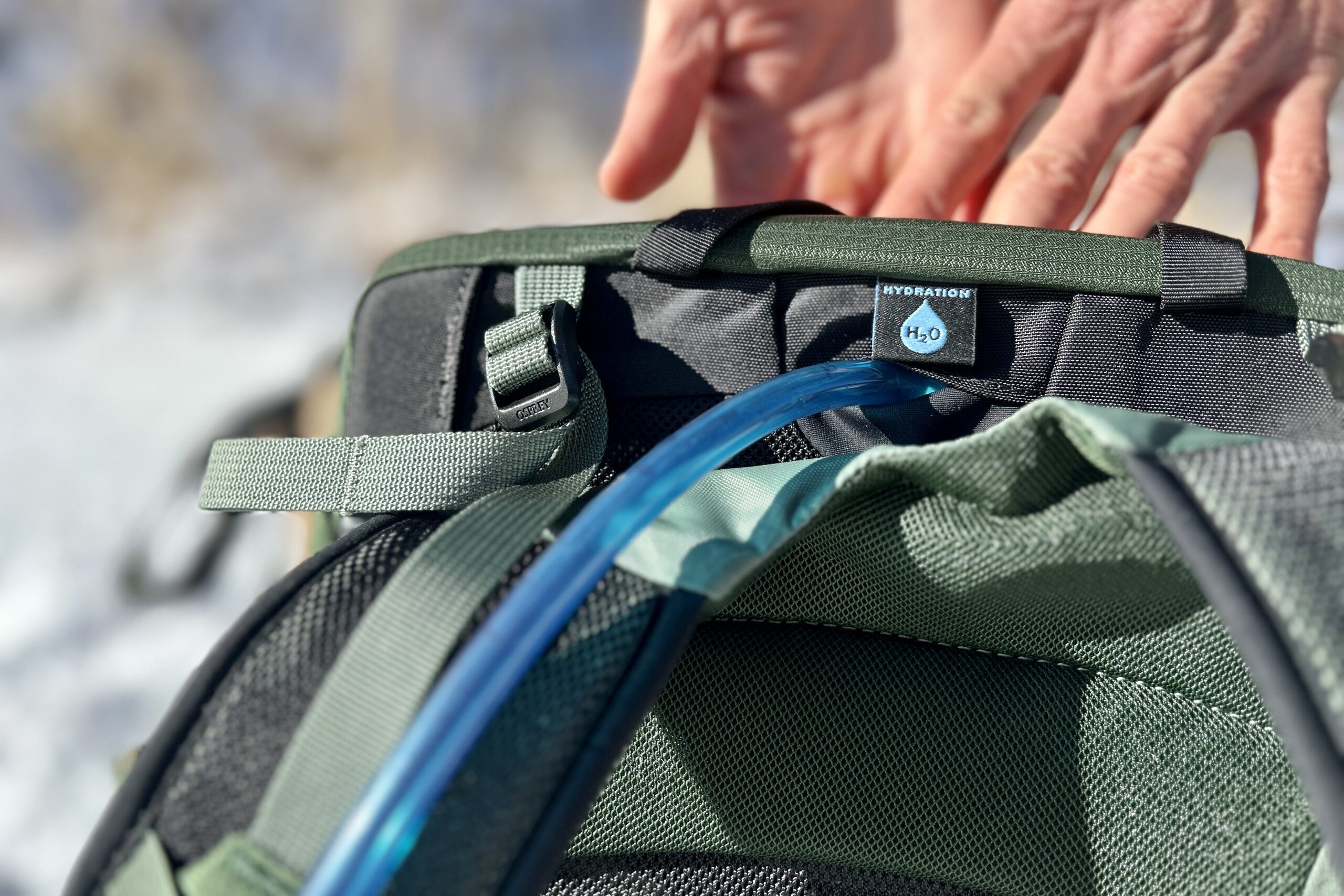 Close up of the hydration tube routing out of the top of a backpack.