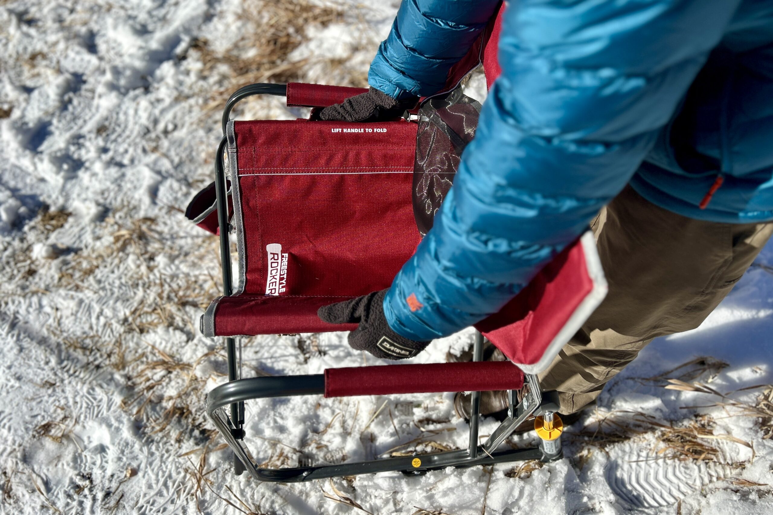 Top-down view of a person collapsing a camping chair.