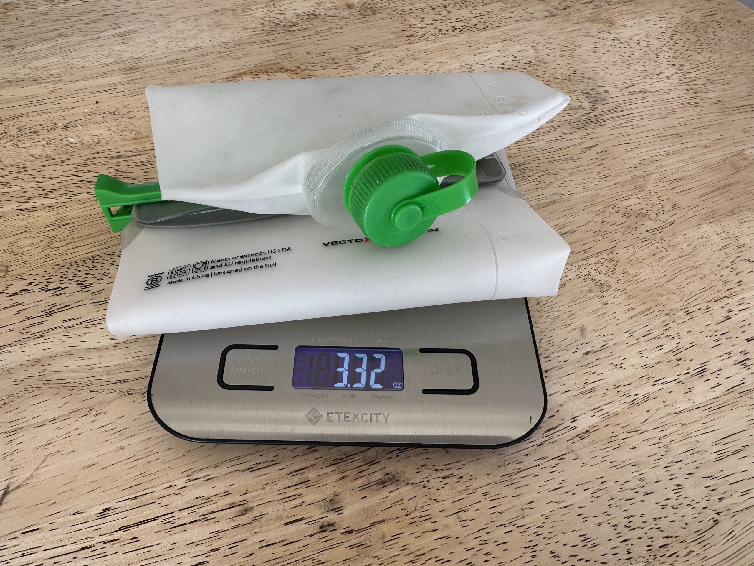 Close up image of the CNOC VectoX water container on a scale on a table. The scale reads 3.32 oz.