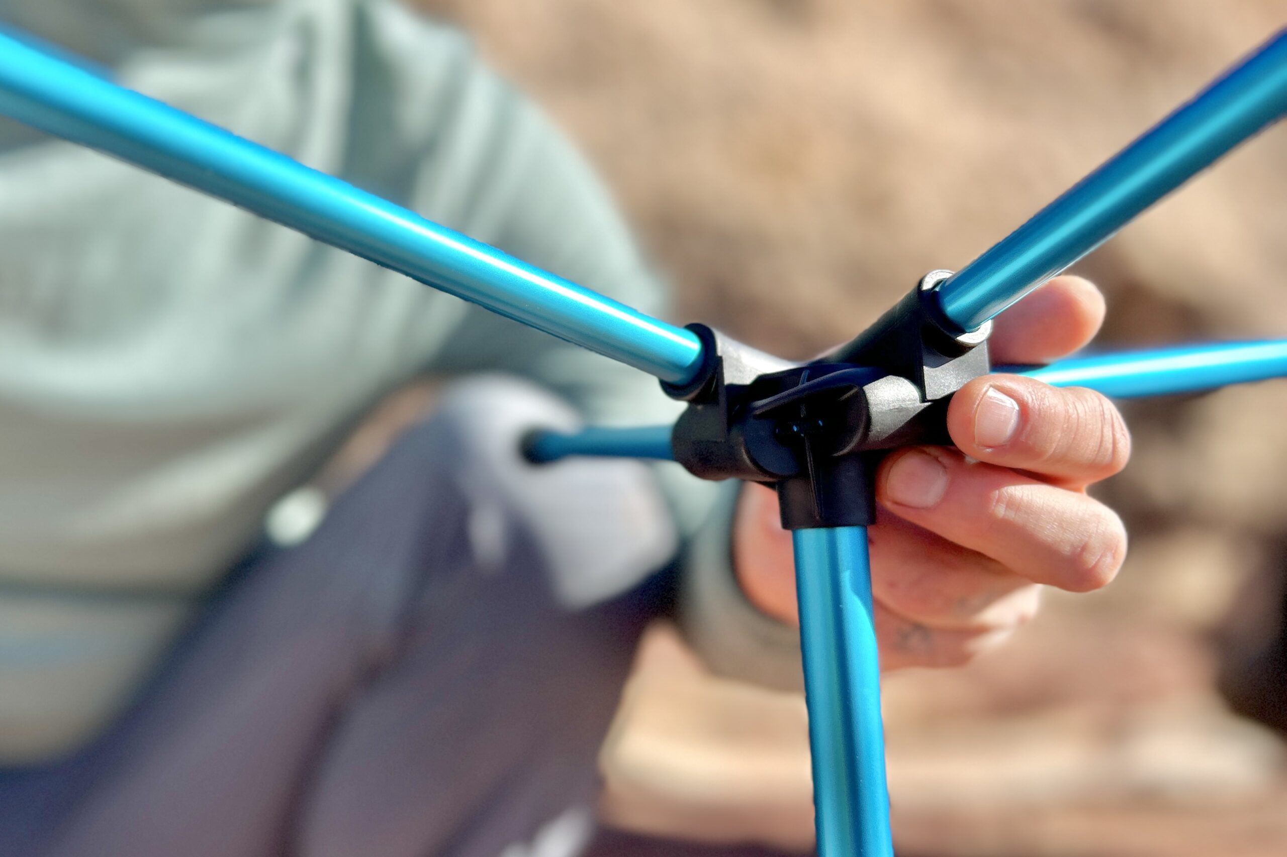 Close up of the connection hub of a camping chair with the poles inserted.