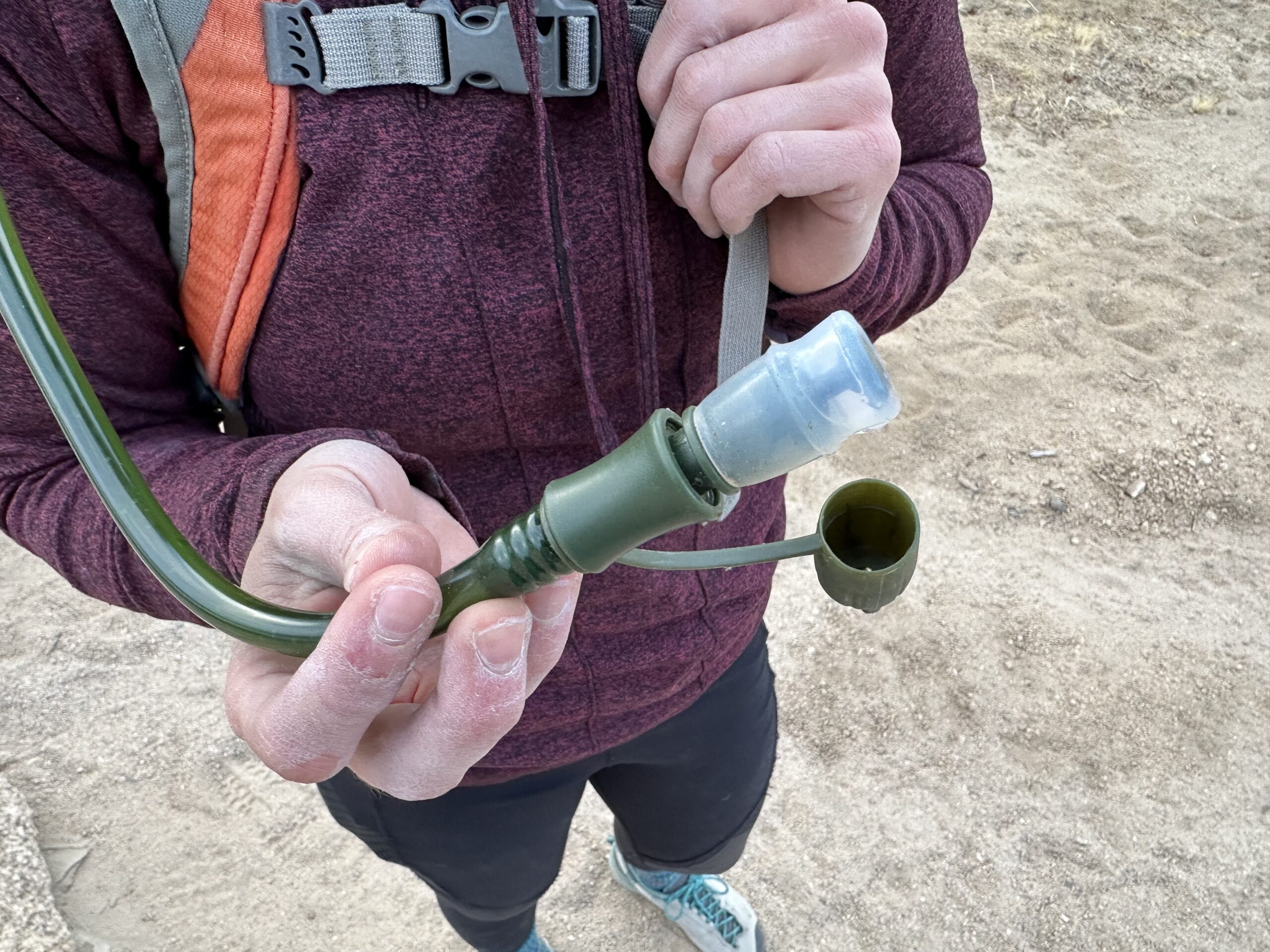 Close up of a hiker holding the bite valve on the Cherainti Bladder
