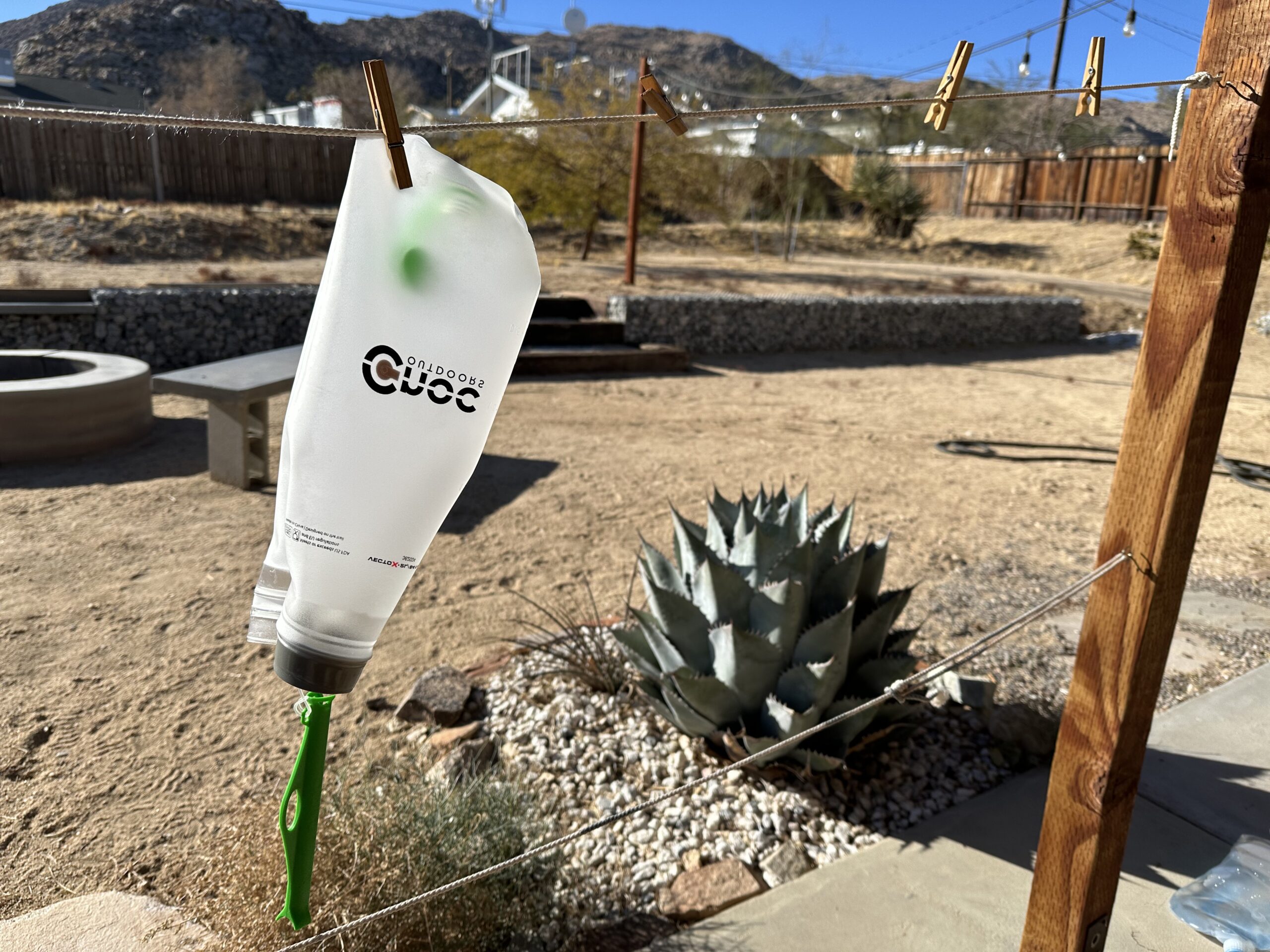 Photo showing the CNOC VectoX turned inside out and hanging from a clothesline to dry. A desert backyard is in the background.