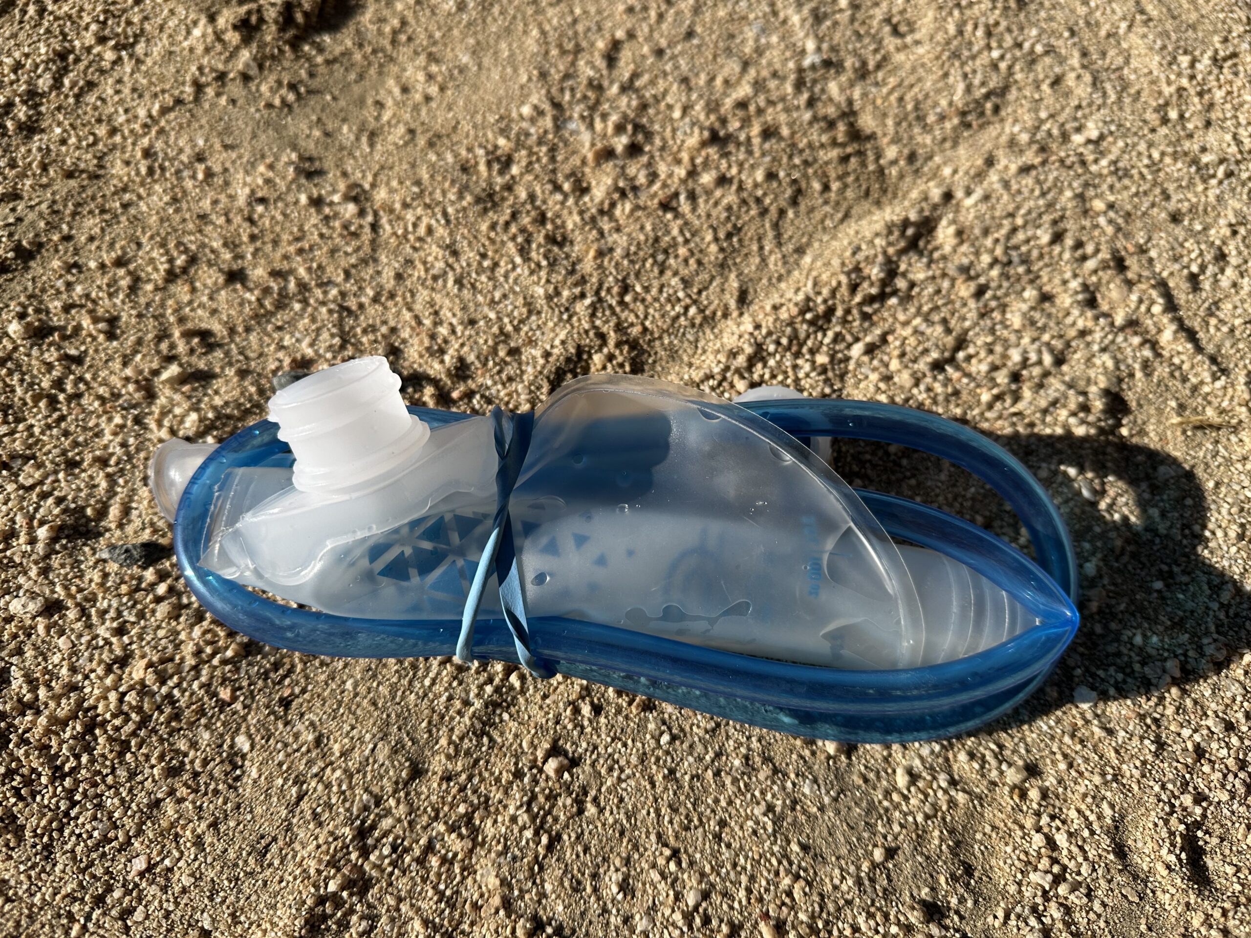 Close up photo of the Platypus Hoser Reservoir emptied out, rolled up and secured with a rubber band, showing its small packed size.