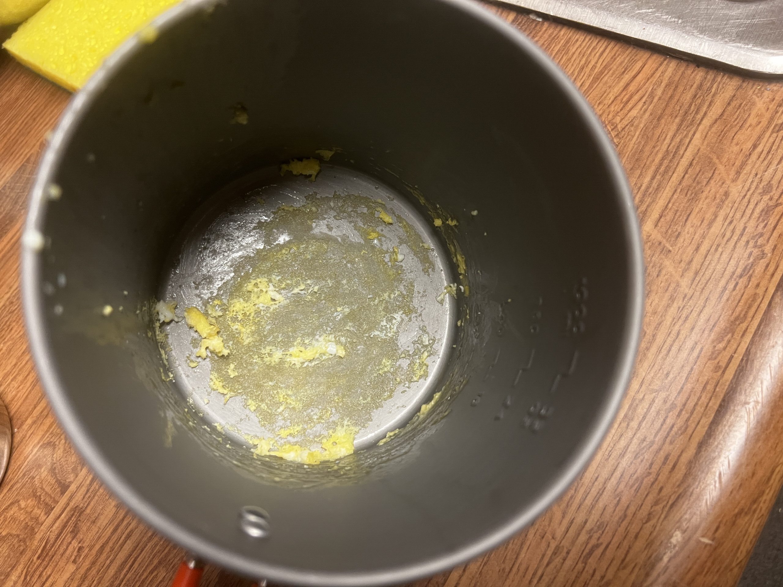 A top down view of a pot with burned egg on the bottom.