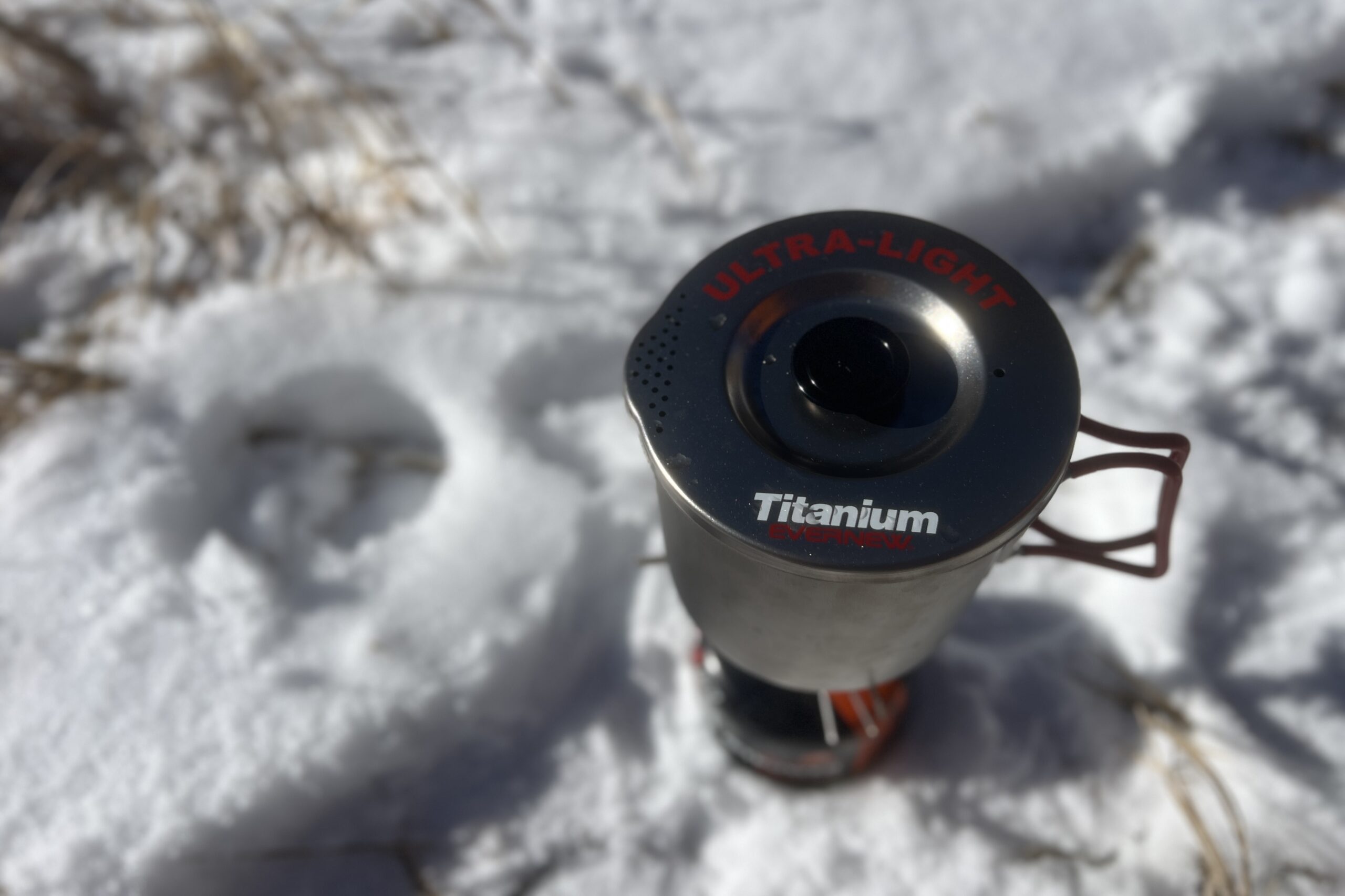 A top shot of the evernew pasta pot with its lid on and sitting on top of a stove with a snowy background.