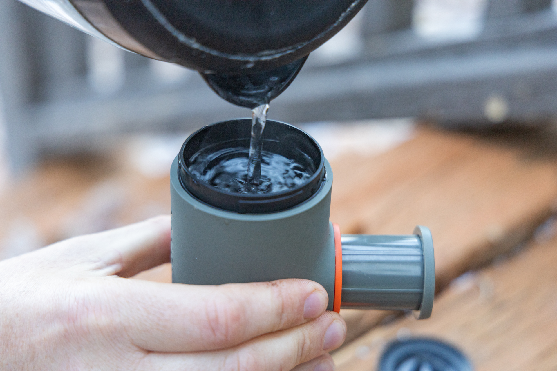 Pouring water into the reservoir of the Wacaco Minipresso.