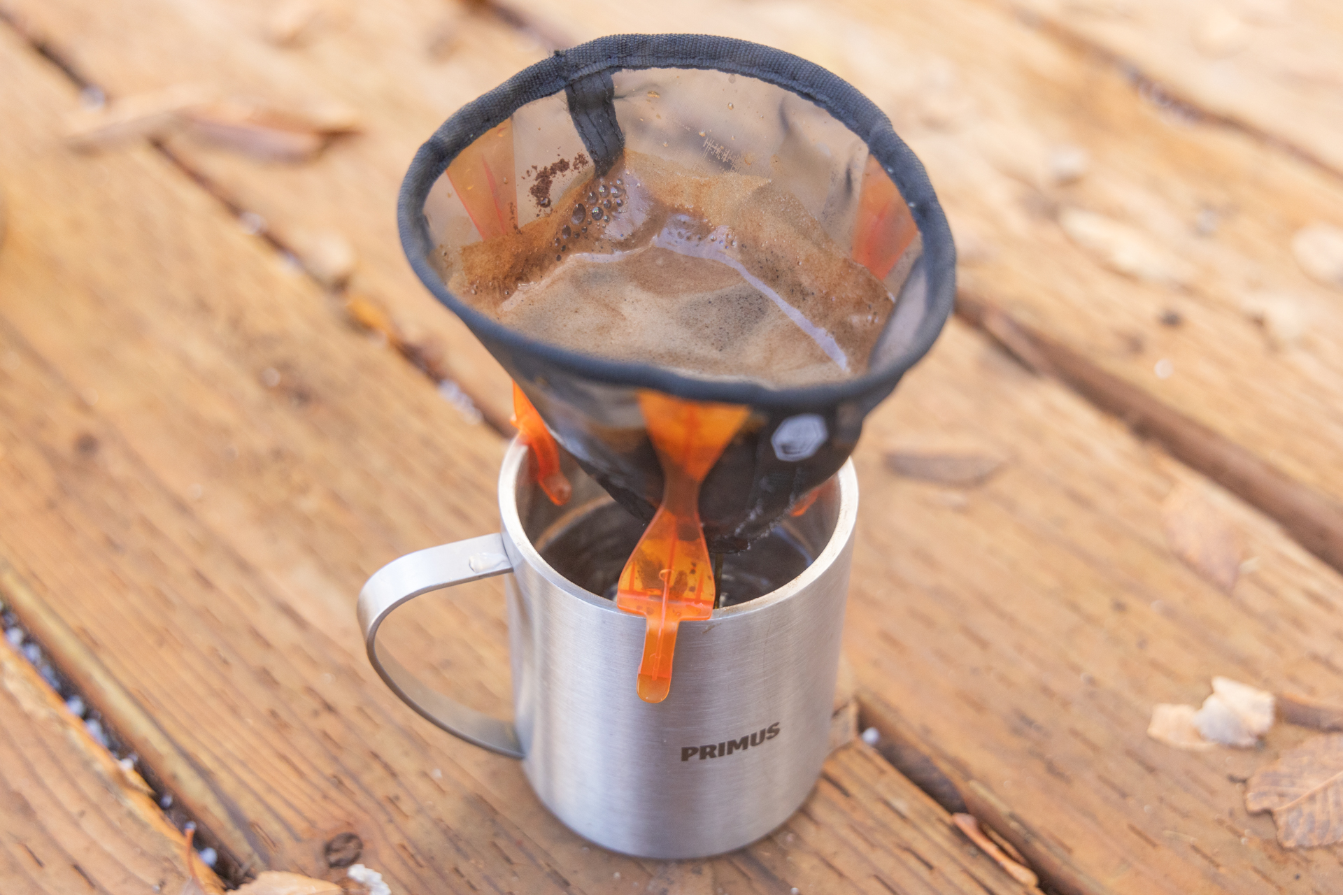 The GSI Ultralight Java Drip full of grounds and water dripping into a camp mug.