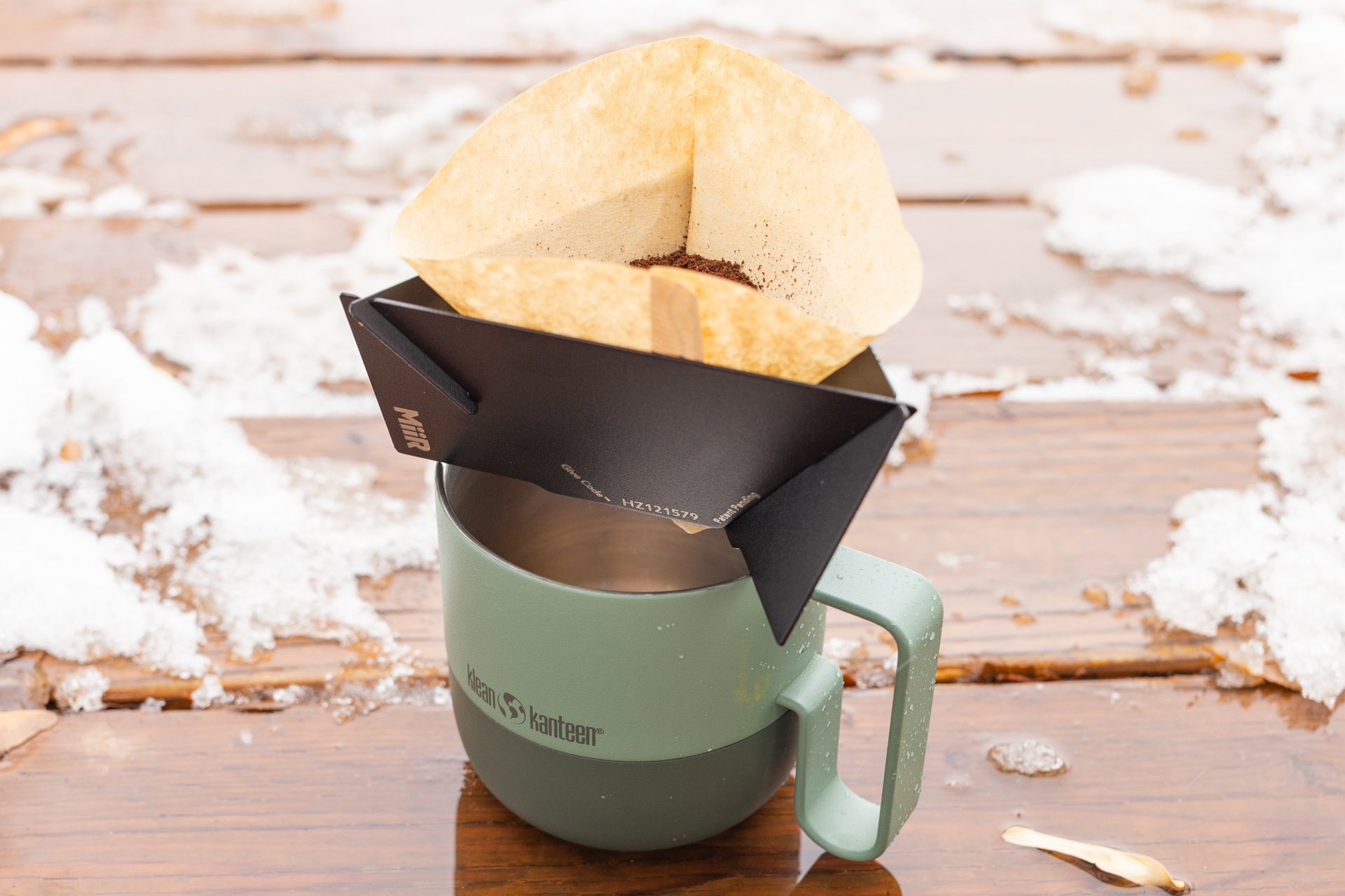 Dry coffee grounds in a filter in the MiiR Pourigami sit atop a mug.
