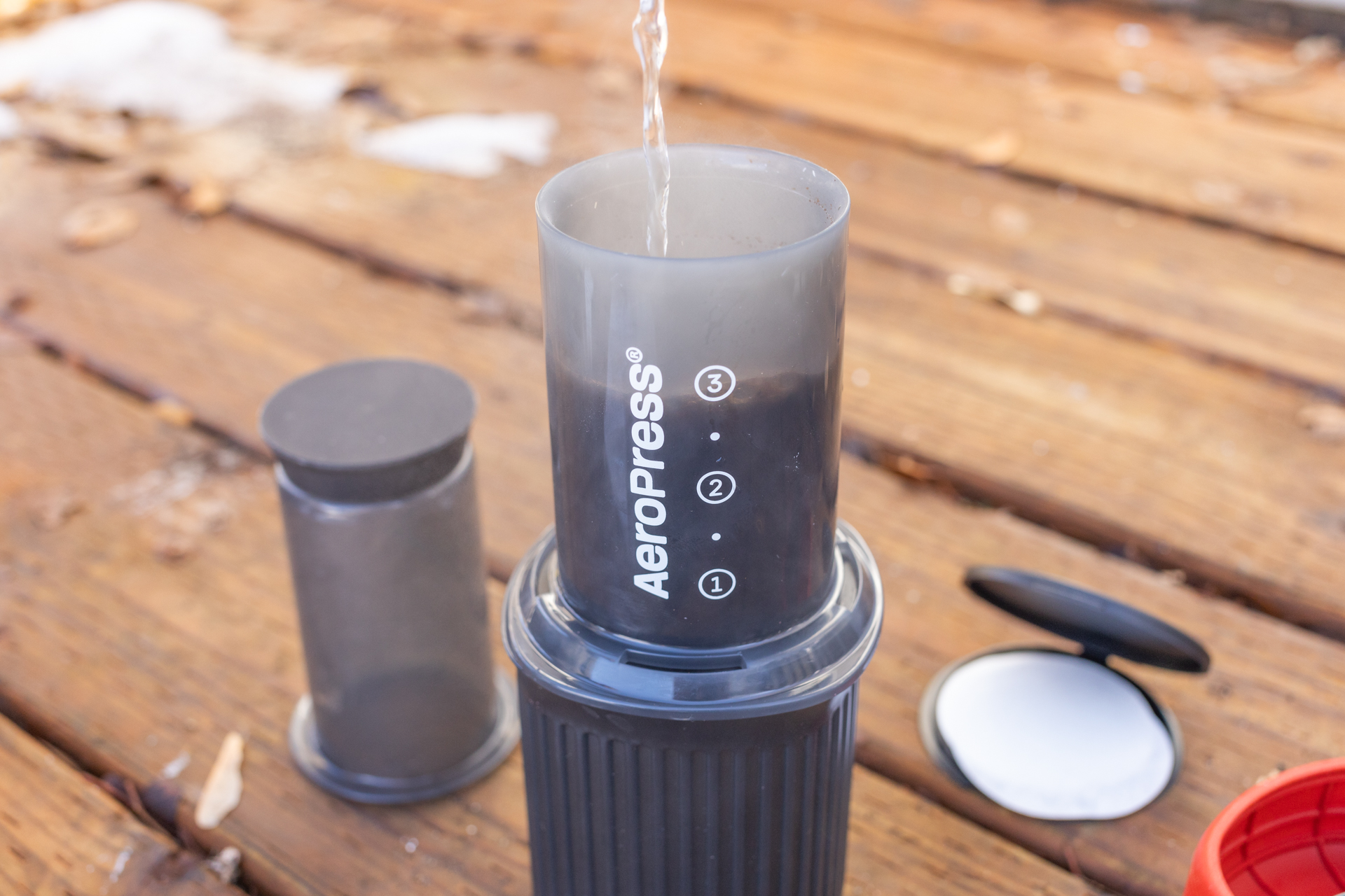 Pouring water over coffee grounds in an Aeropress Go.