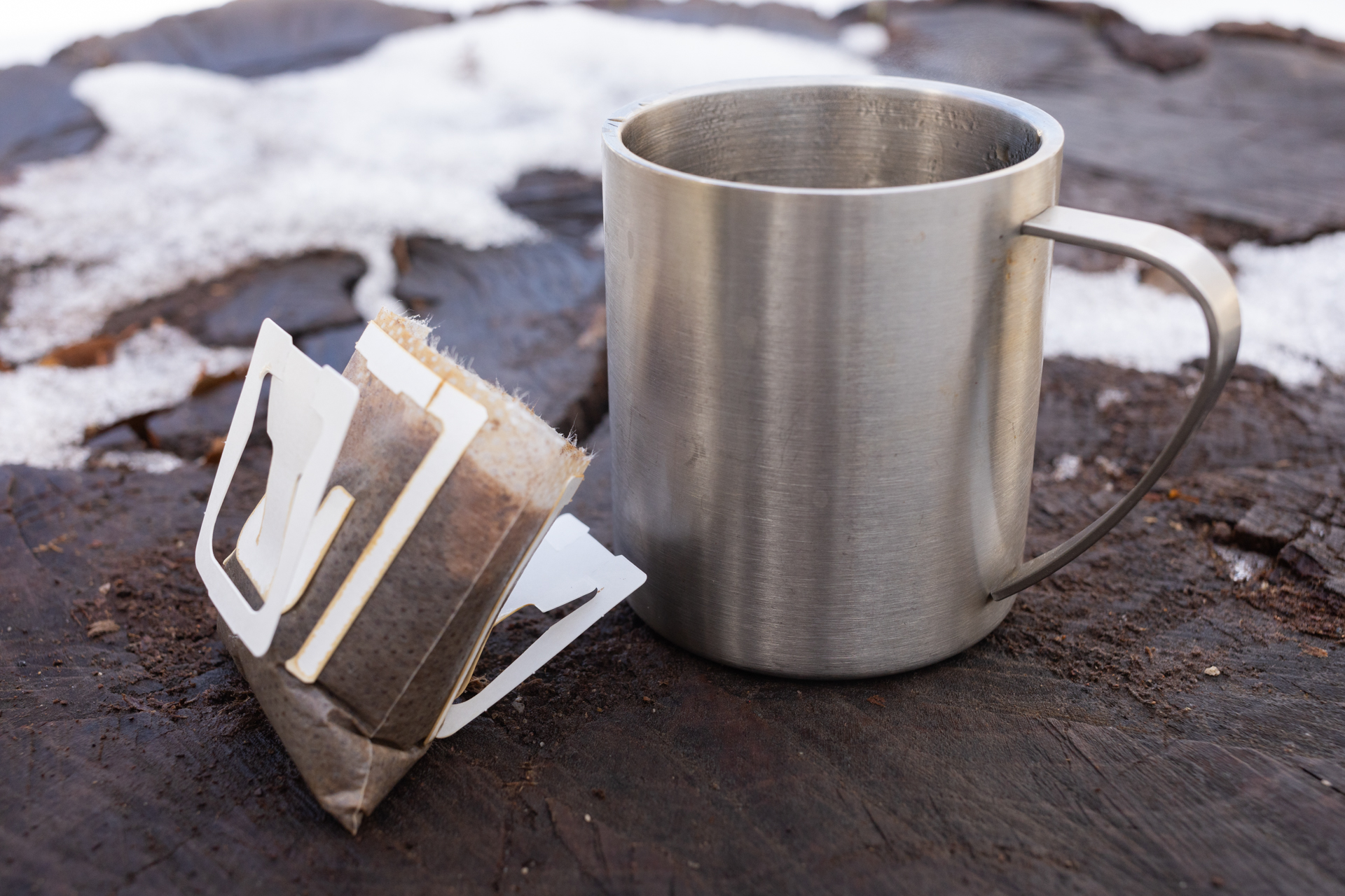 A Kuju coffee pouch next to a mug.