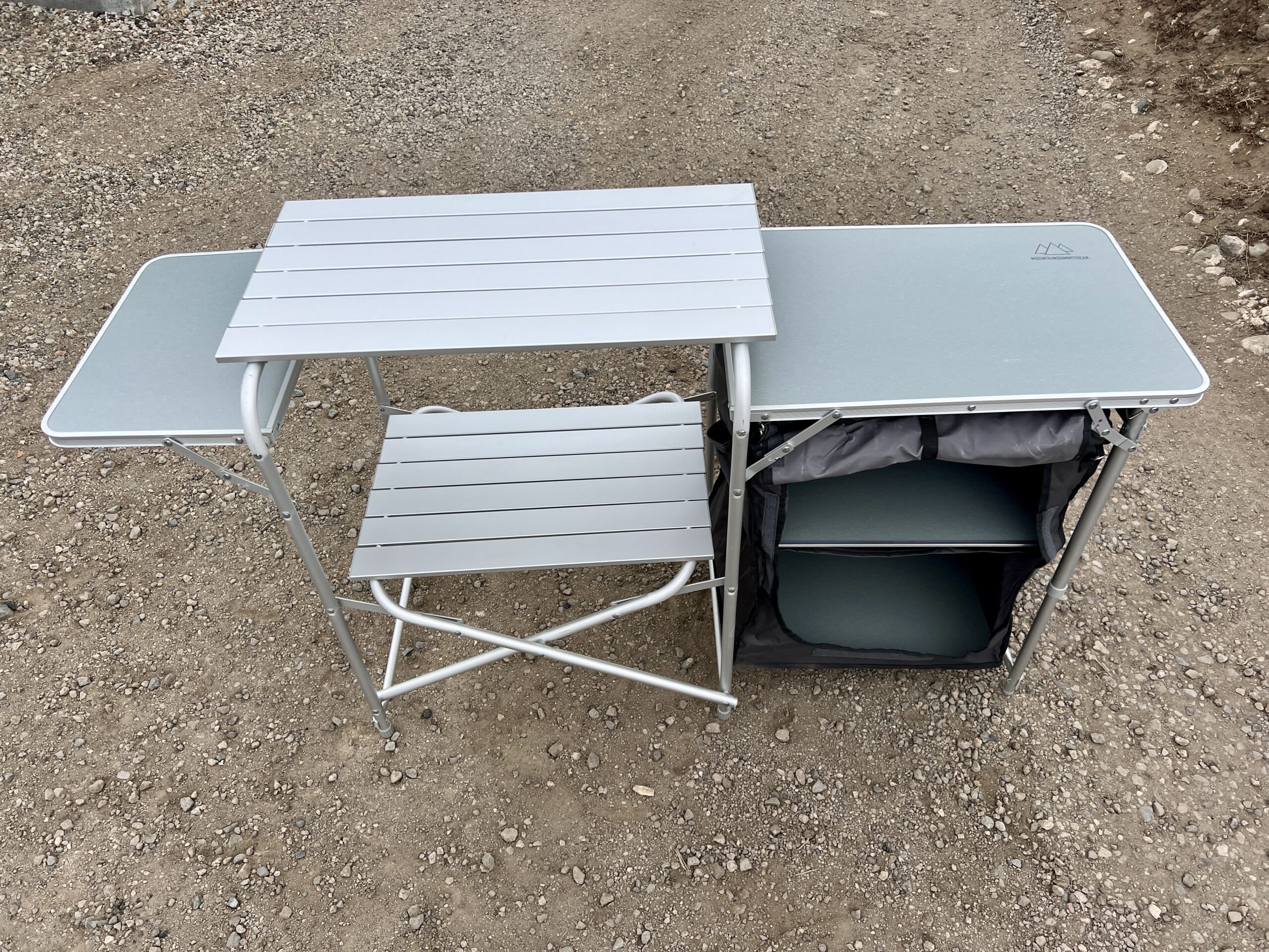 The Mountain Summit Gear Deluxe Roll Top Kitchen stands empty on gravel.