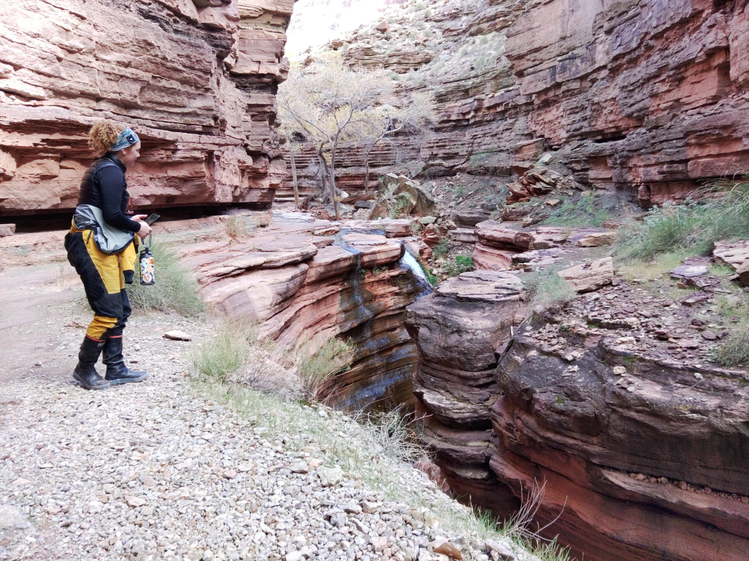 a person in a red rock canyon wearing xtratuf rain boots