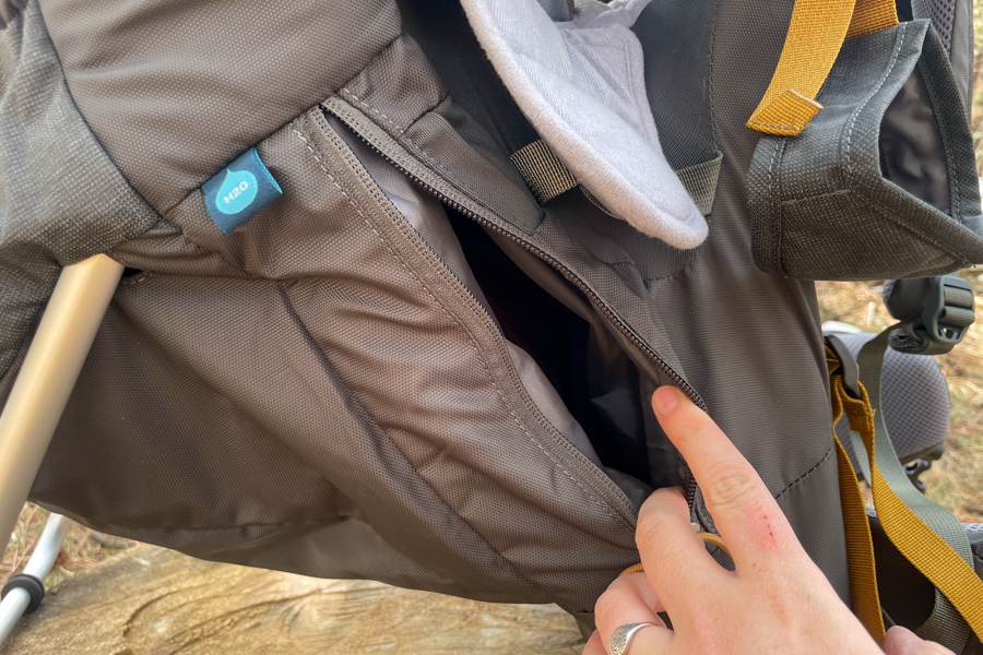 A rear view of an adult carrying a Kelty Journey PerfectFIT Signature baby carrier on a hike through a forested area.