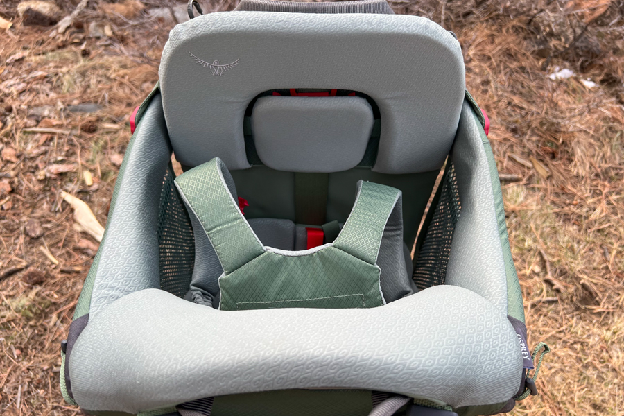 A close-up of the child seating area in the Osprey Poco Premium, highlighting the comfortable padding and secure harness system.