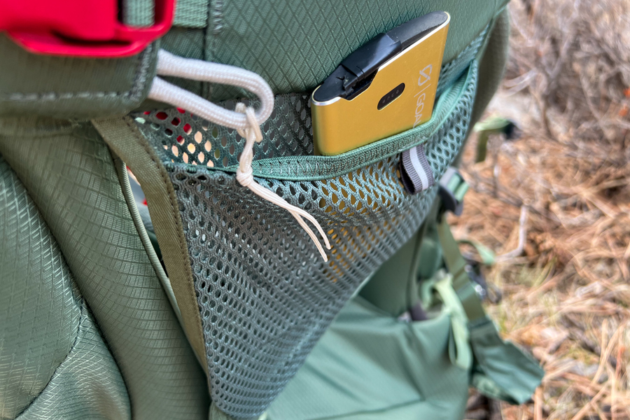 A close-up of the mesh side pocket on the Osprey Poco Premium, holding a small accessory for convenience.