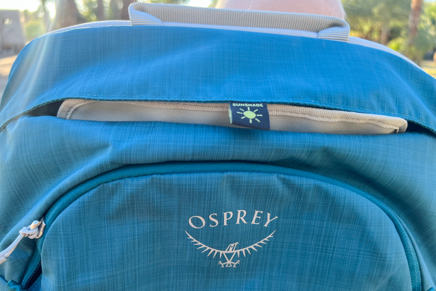 Close-up of the Osprey Poco SLT carrier’s integrated sunshade tucked neatly into the storage compartment, showcasing its thoughtful design.