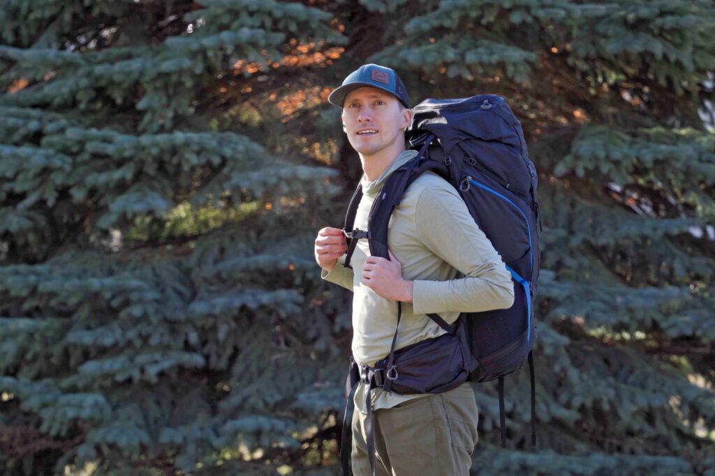 a man wearing a black and blue backpack