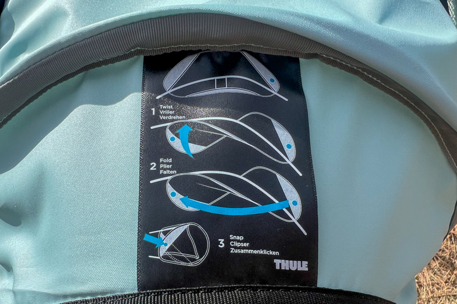 Illustration of the sunshade folding instructions included with the Thule Sapling child carrier.