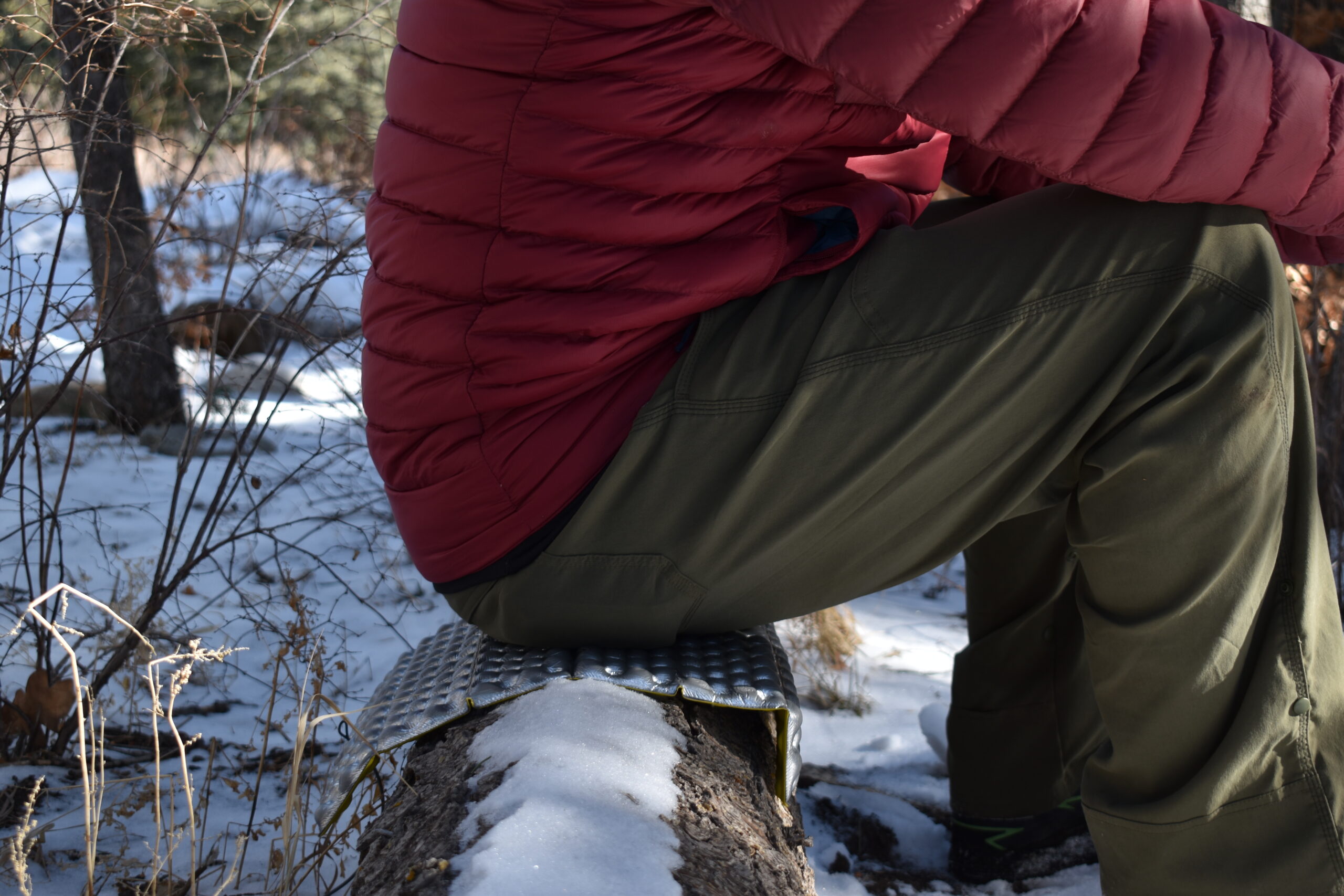 Therm-a-Rest Z-Seat on a log, which it cushions a male hiker's seat