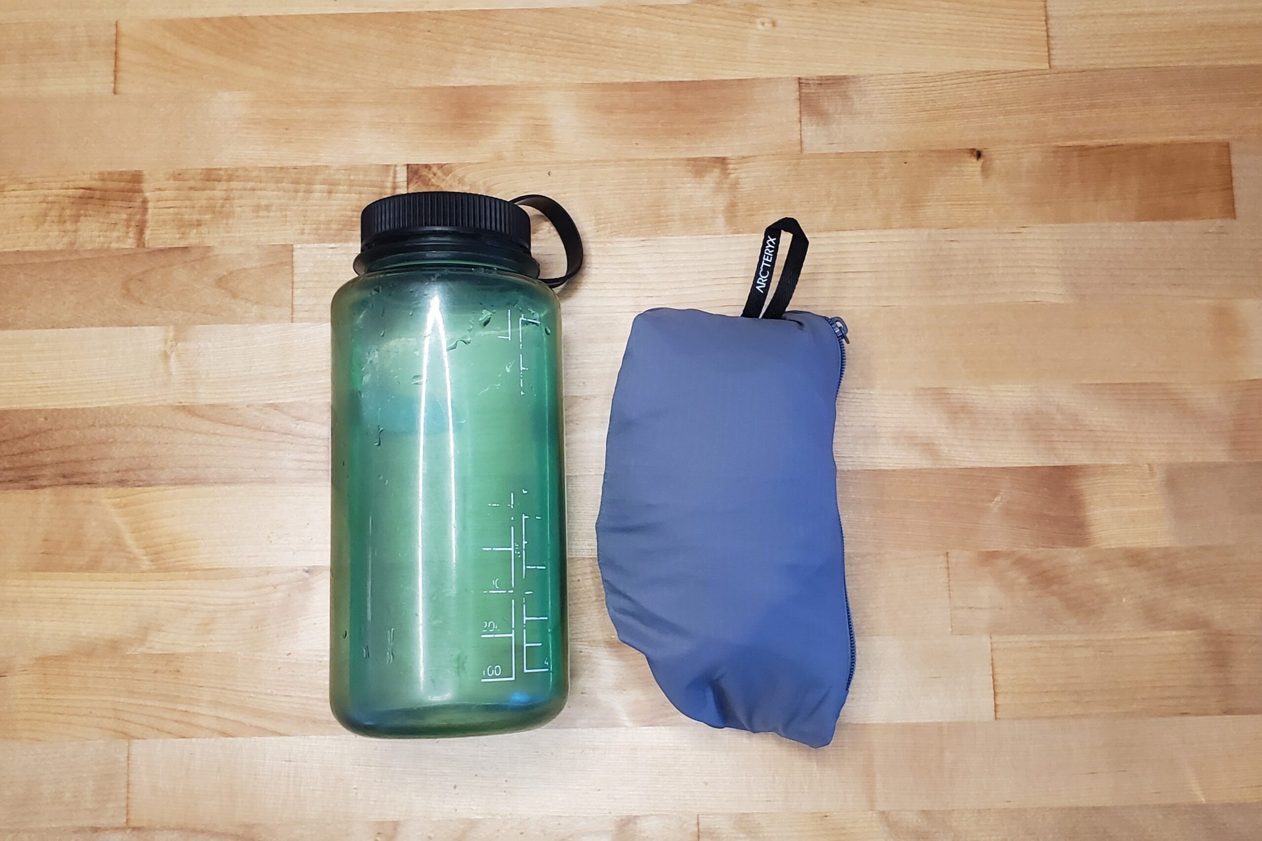 A packed windbreaker compared to a water bottle.