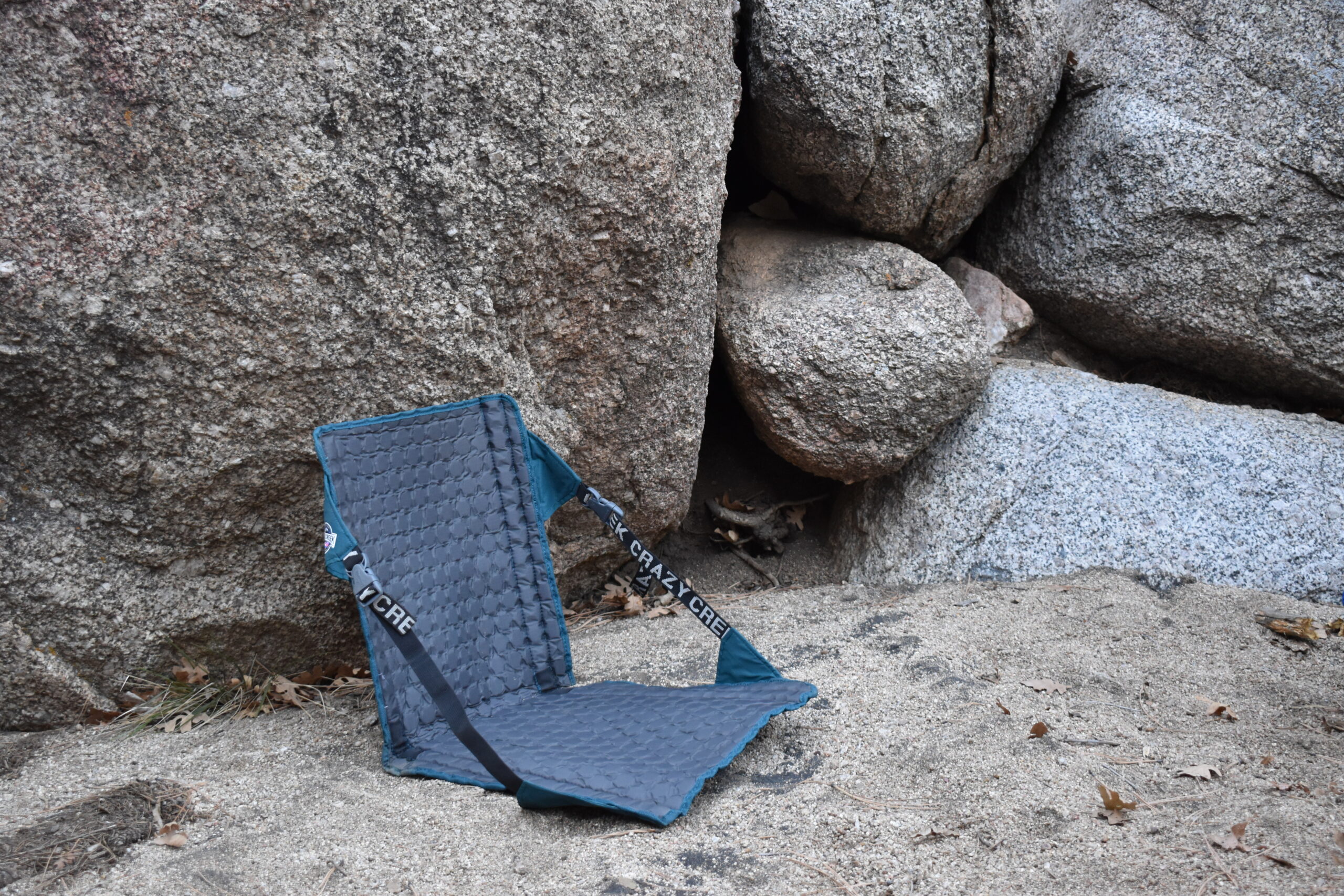 The Crazy Creek Hex 2.0 sits upright against some boulders to show its top and bottom cushions