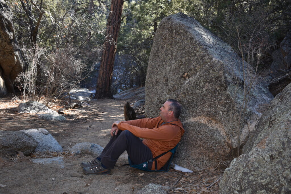 a hiker rests in the Hex chair in a desert wash