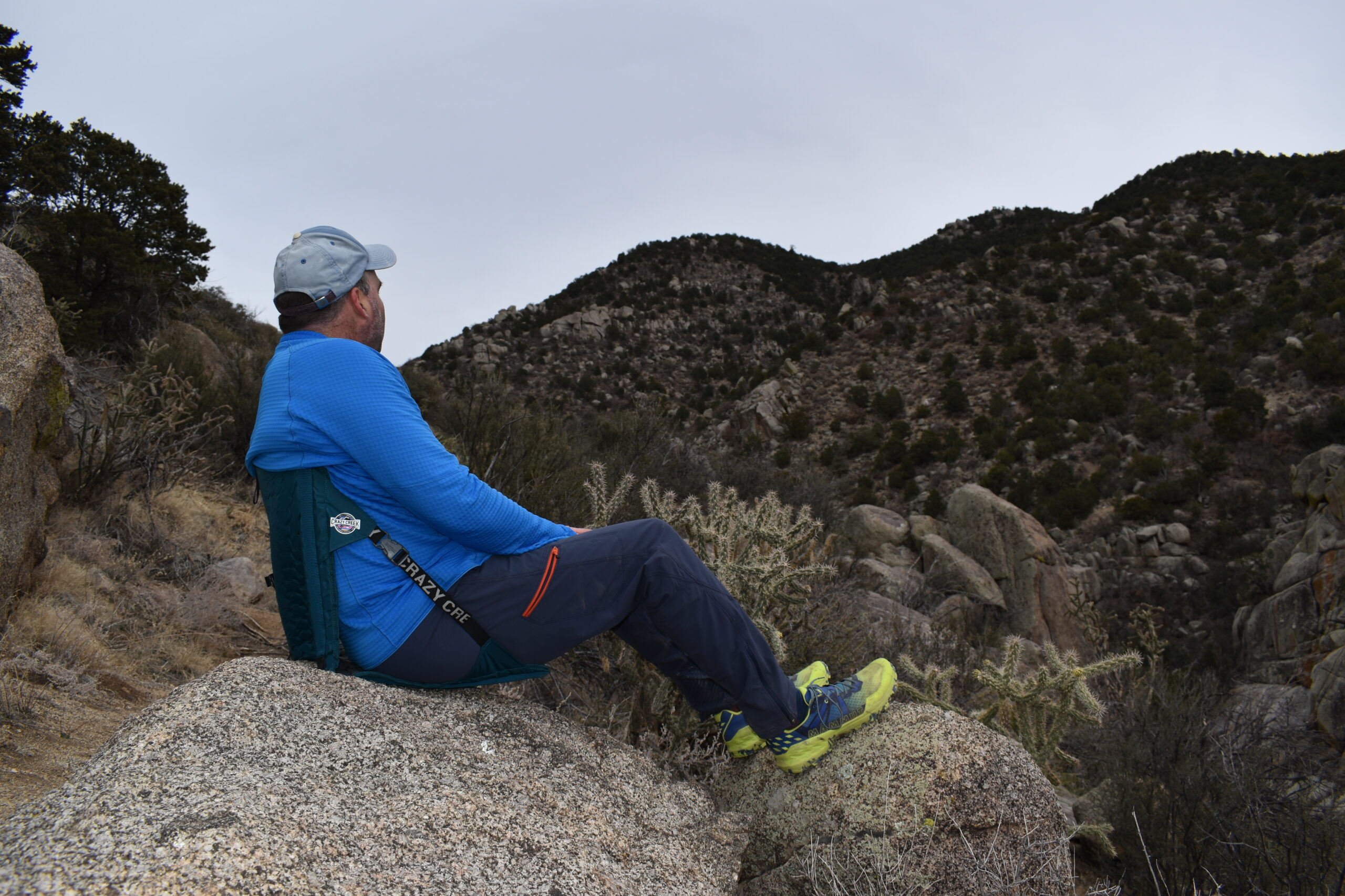 hiker sits on the Crazy Creek Hex 2.0 on a bolder for extra cushioning and a back rest