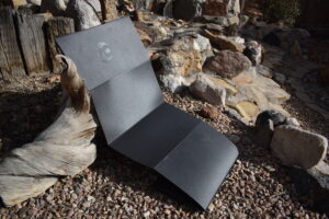 The Gossamer Gear Thinlight pad set up as a recliner with its backrest leaning against a log