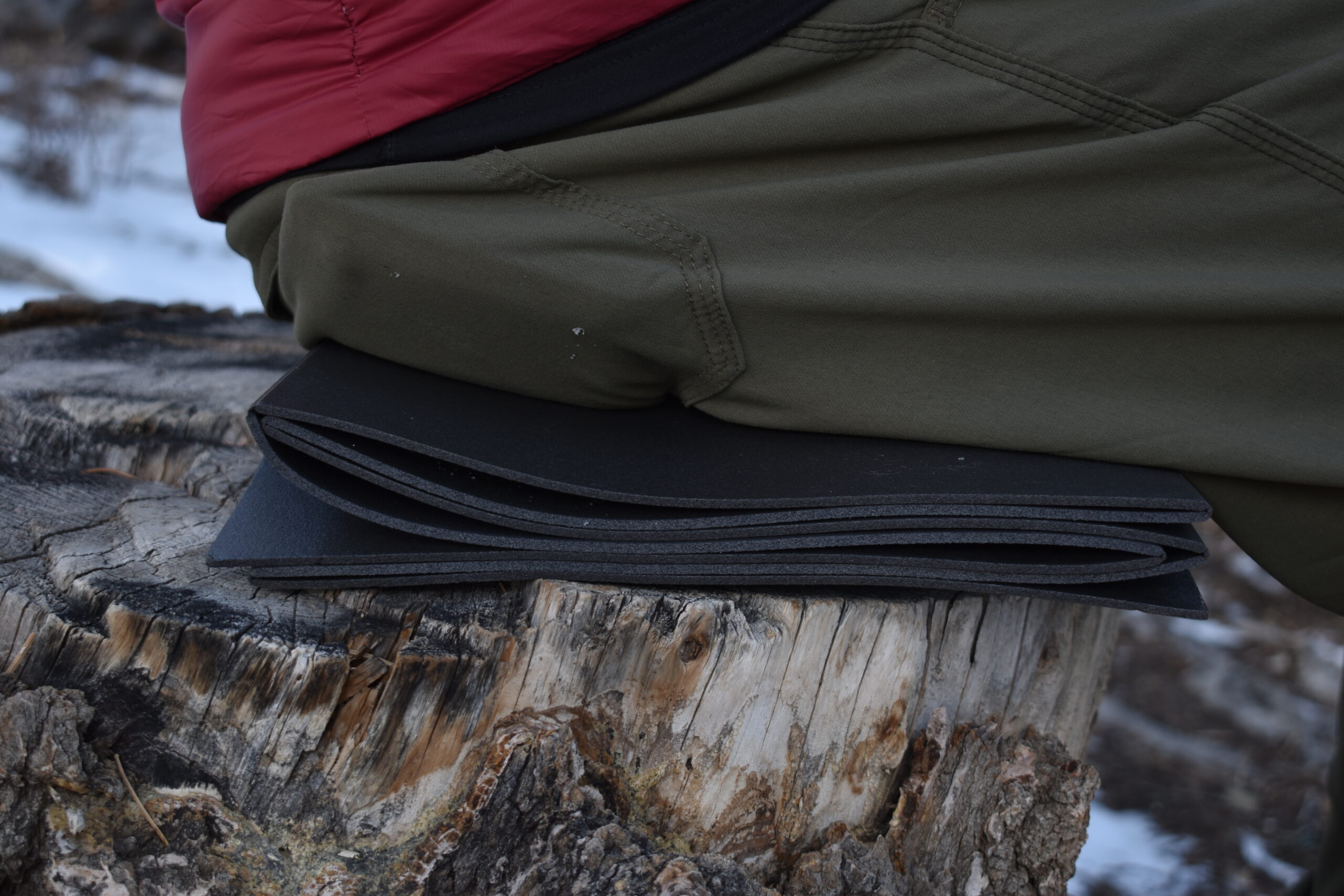close up of a backpacker sitting on the folded Thinlight Pad