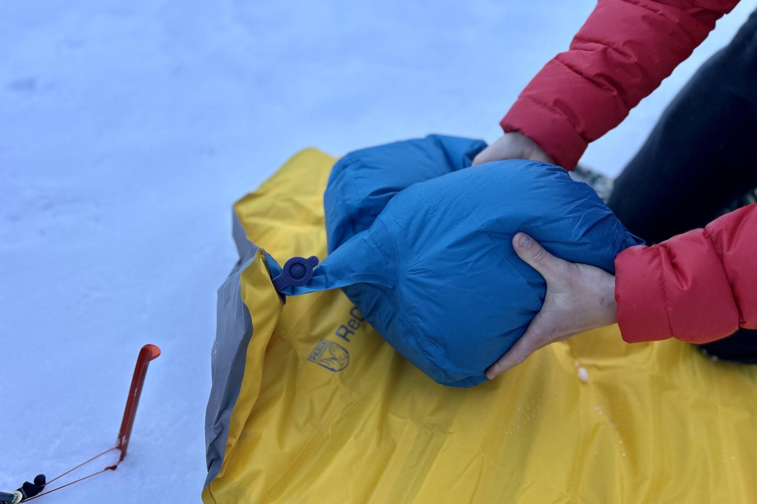 Close-up image of a pump sack attached to the inflation nozzle of a sleeping pad.