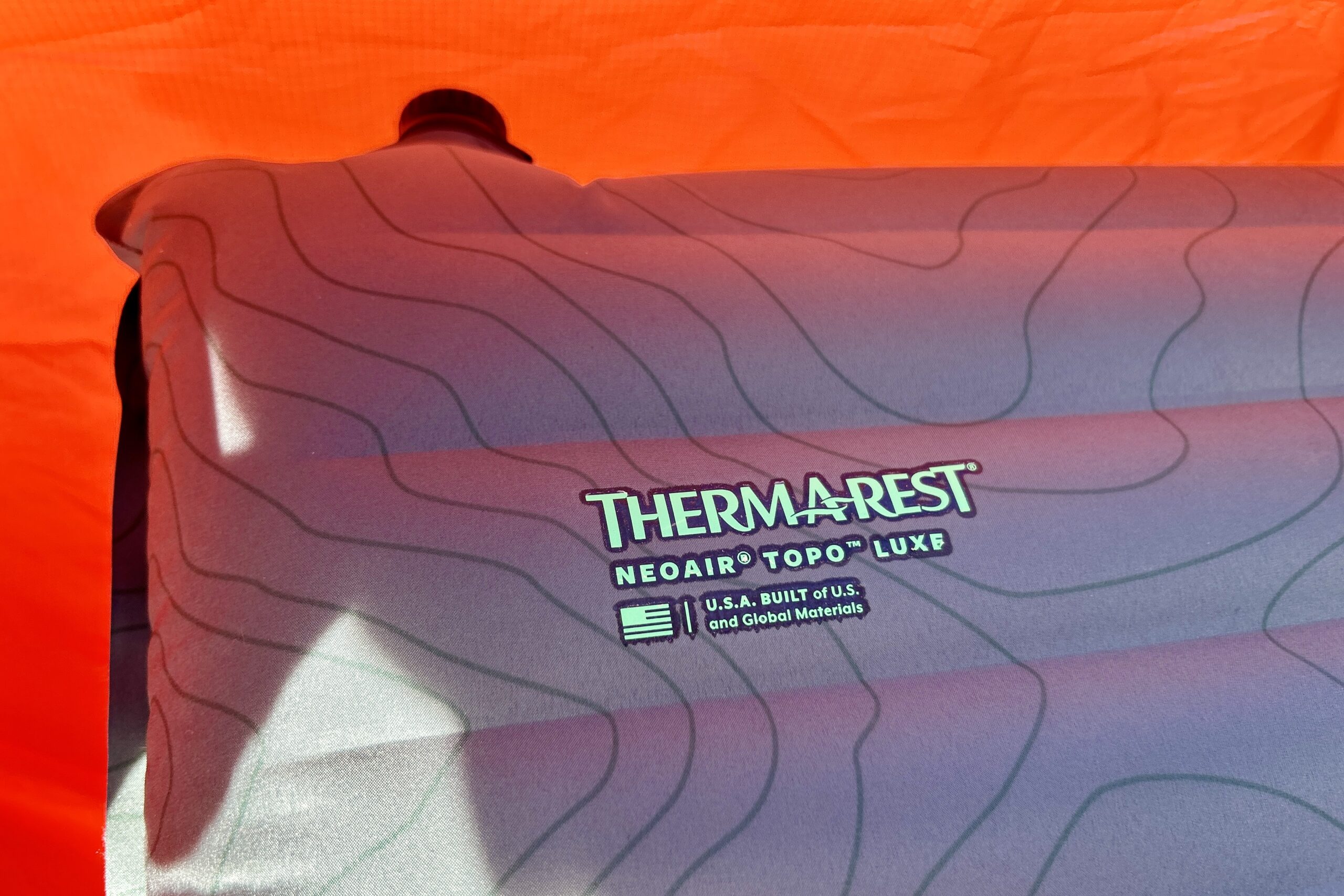 Close-up image of the logo of a camping mattress printed in the corner.