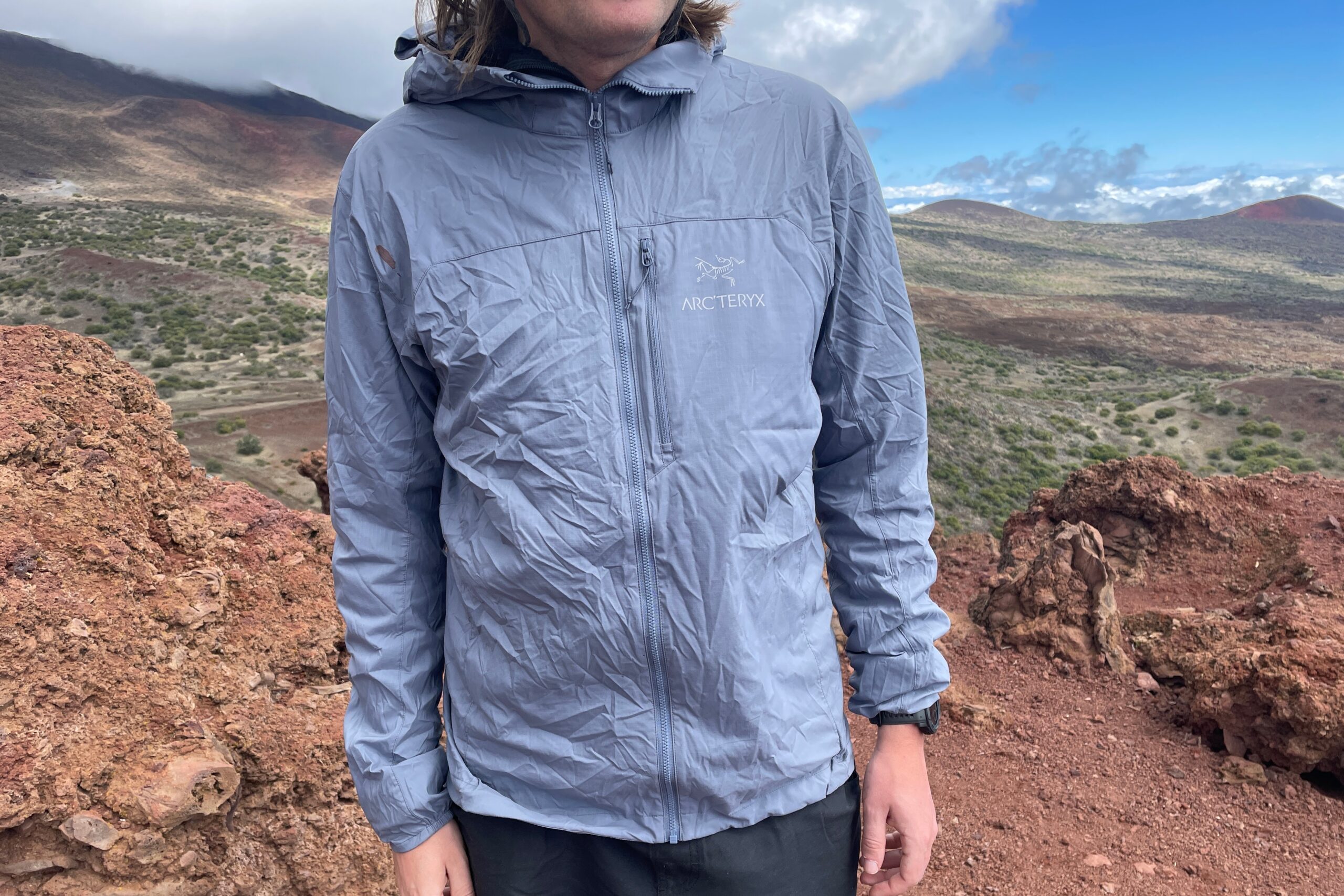 A front of a windbreaker worn on an alpine trail.