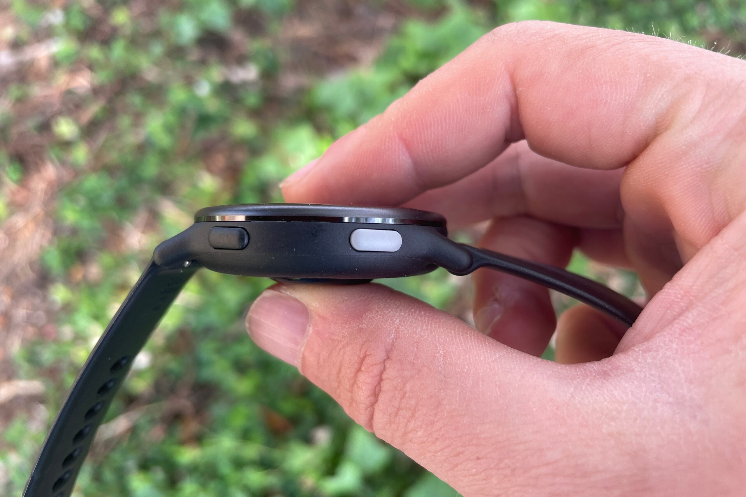 A closeup of the thickness of a watch held between two finger.