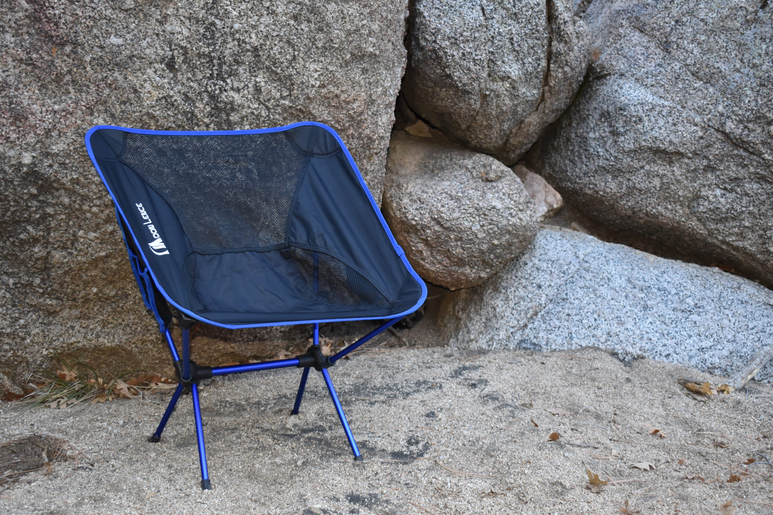 Moon Lence chair set up in front of boulders in a desert canyon wash