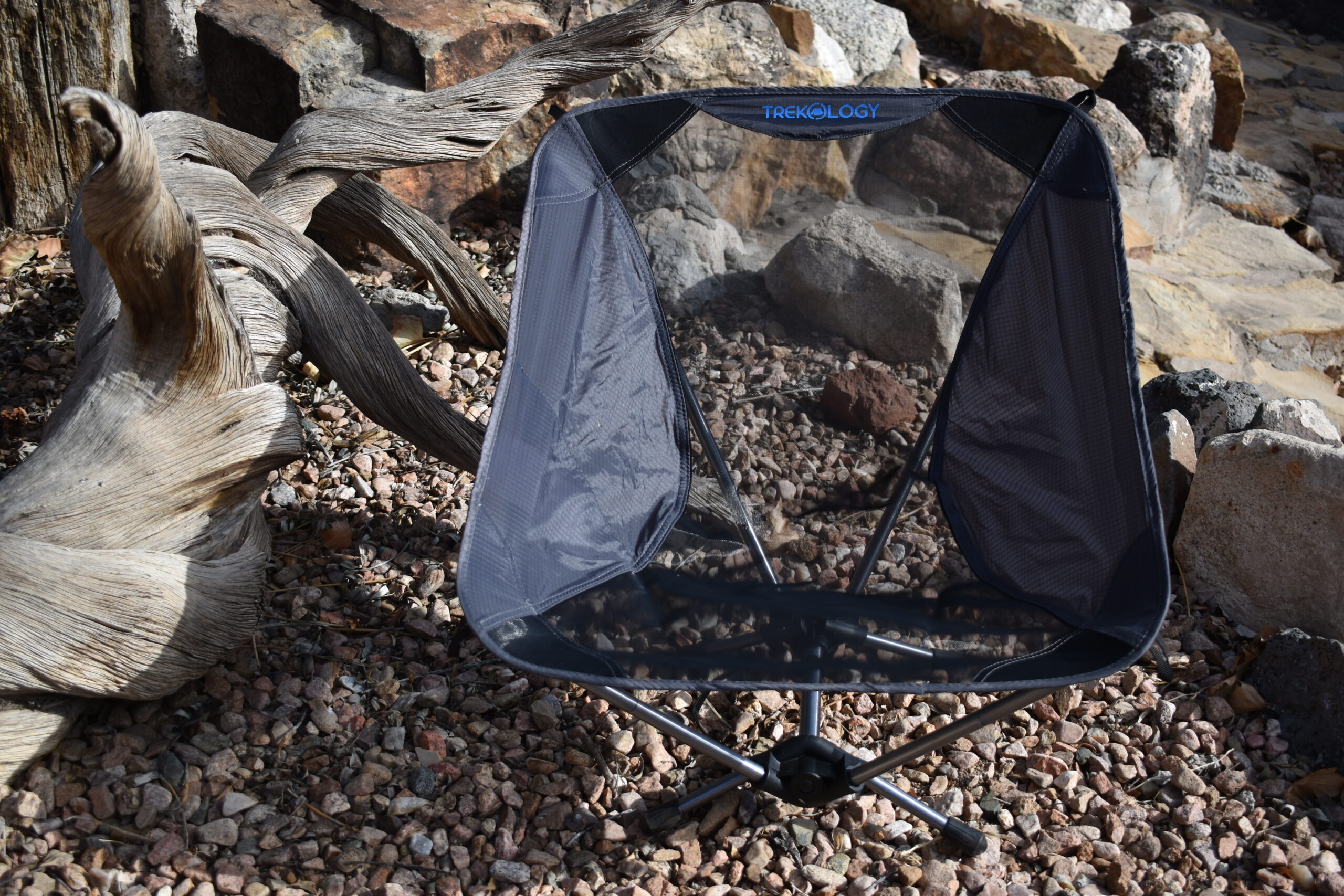 close up front view of the Trekology chair as it sits in a decorative rock garden