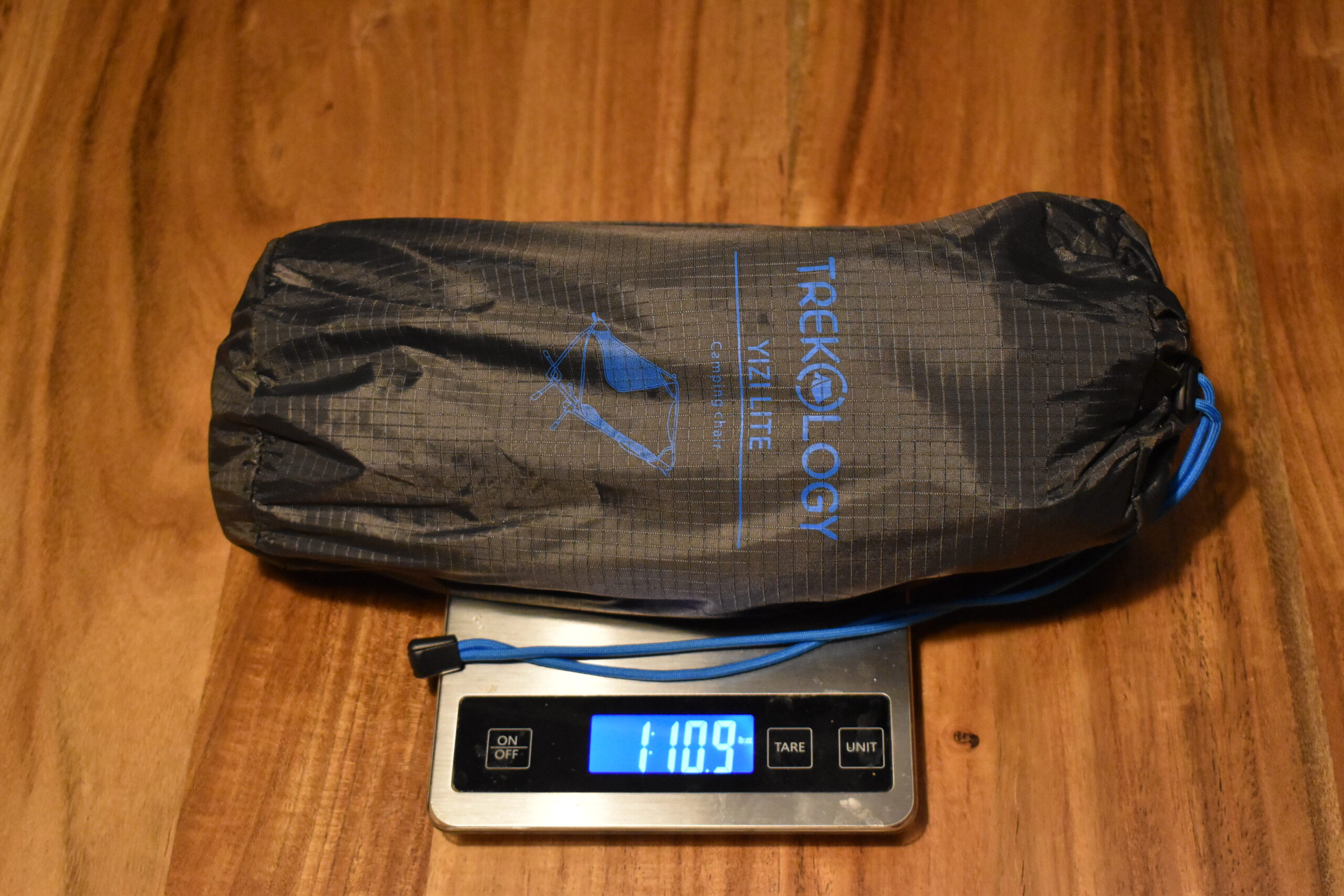 The packed Trekology chair sits on a kitchen scale that reads 1 lb 11 oz