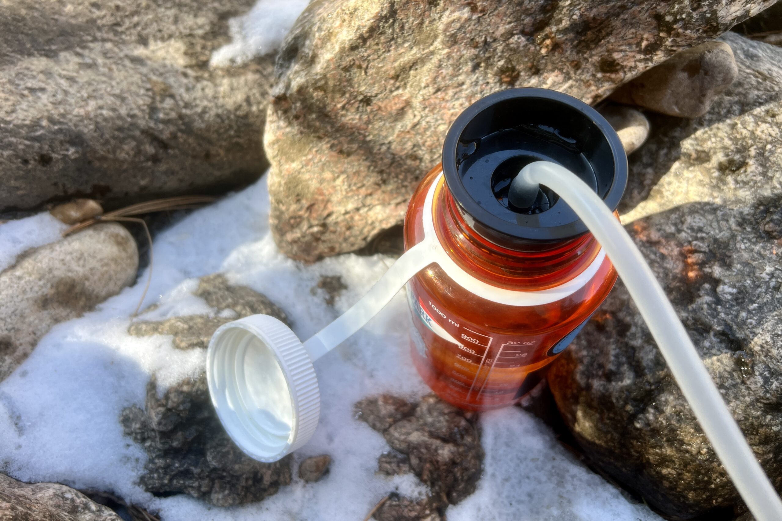 A top down view of the outlet hose attachment of the katadyn hiker filter on a nalgene bottle.