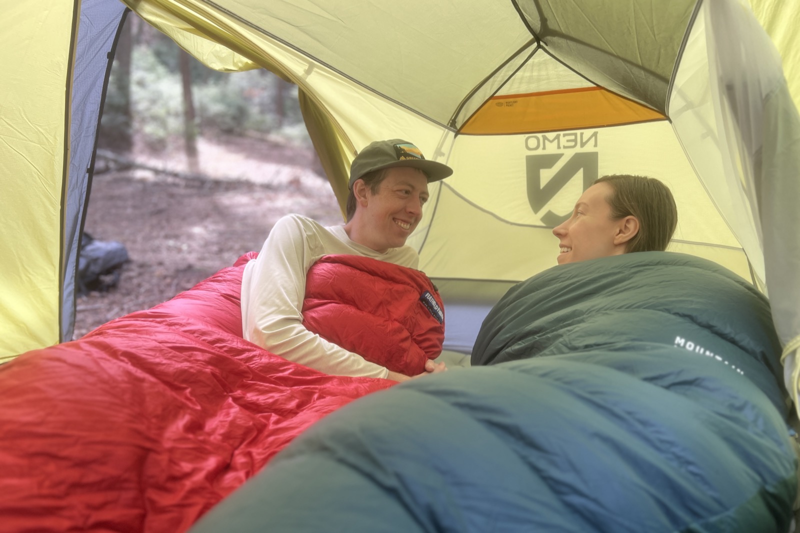 two hikers lay in sleeping bags in a tent