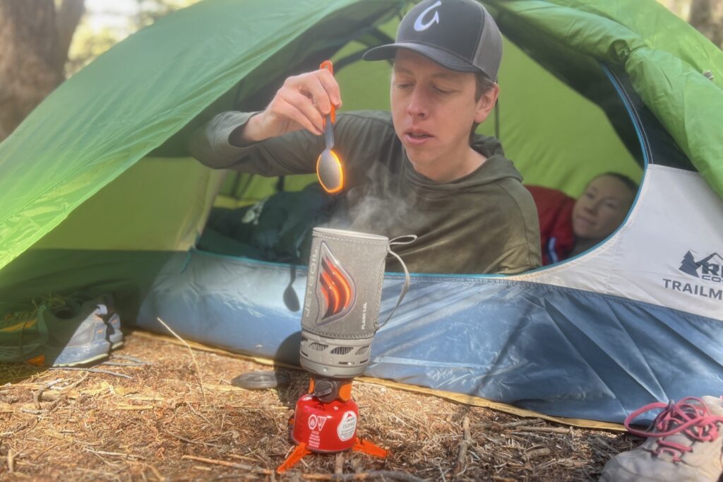 two hikers relax in a tent while cooking with the jetboil flash