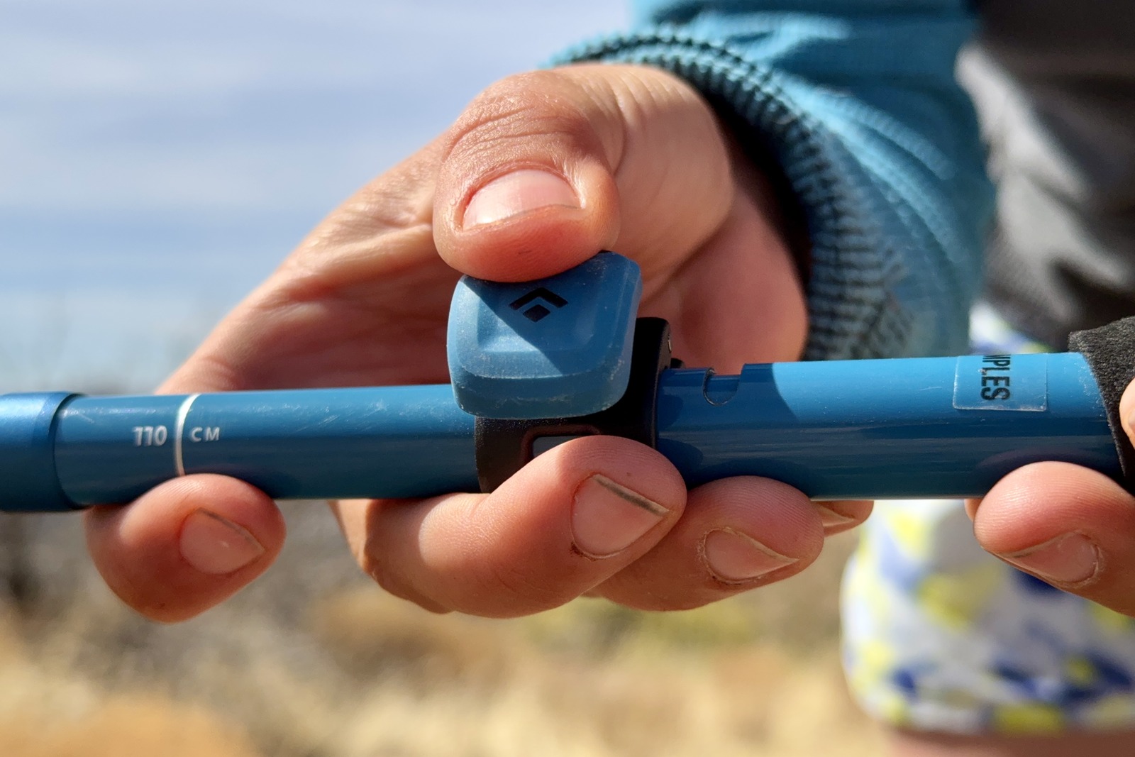 A close up of a person's hand closing the flick lock on the Distance Carbon trekking poles.