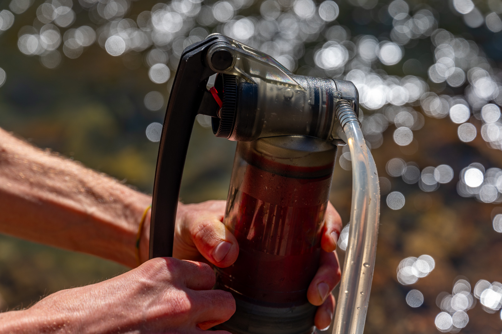 A close up of a hiker pumping with the msr guardian filter