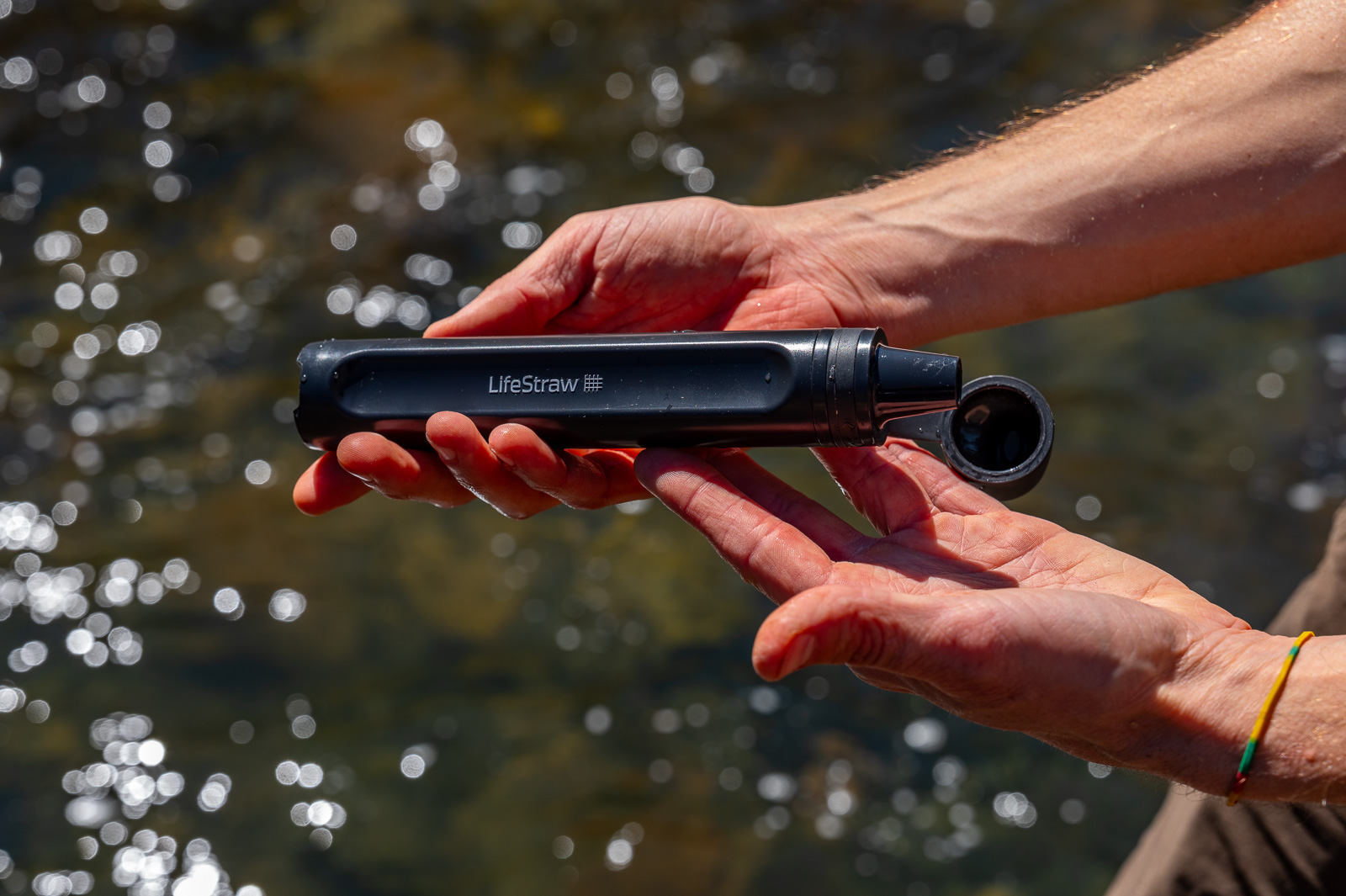 A close up of hands holding a straw water filter