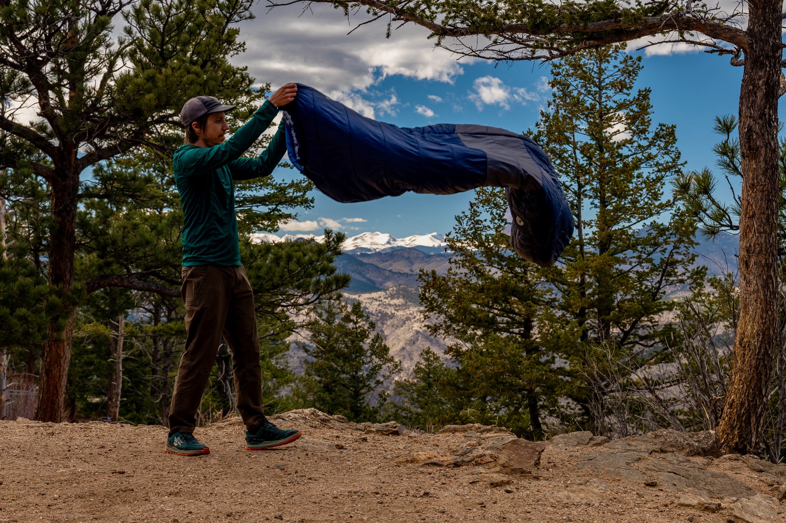 A hiker tosses a sleeping bag