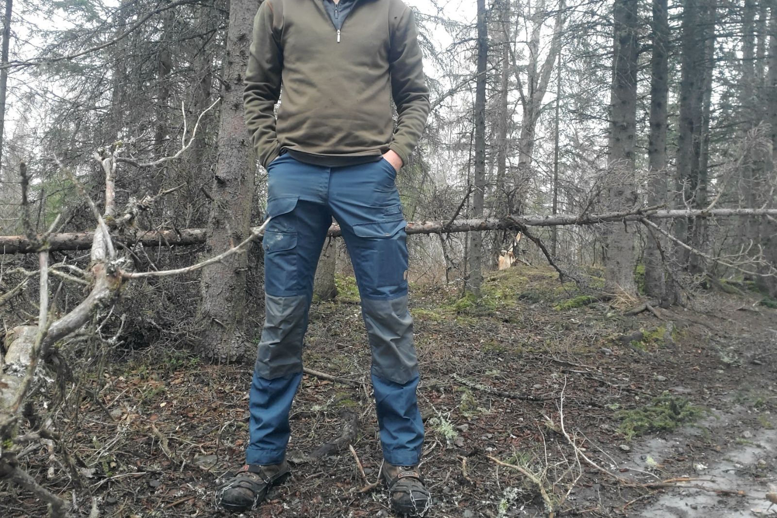 A front shot of a man standing wearing blue pants.