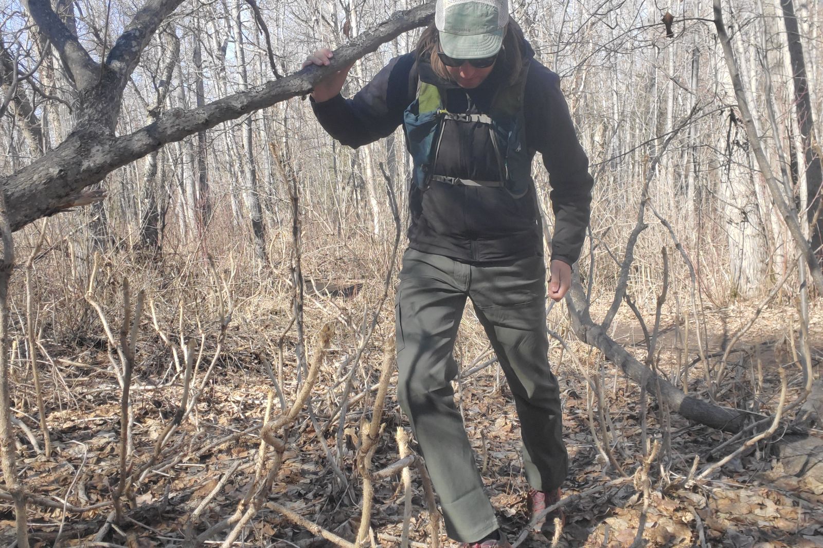 A man hikes off trail through brush.