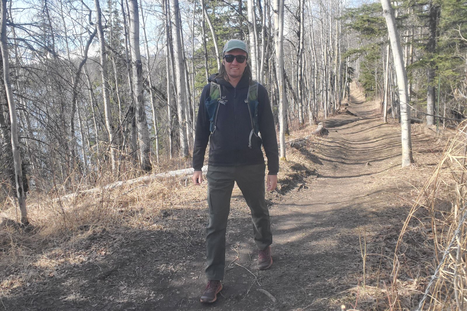 A man hikes up a hill on a trail in spring.