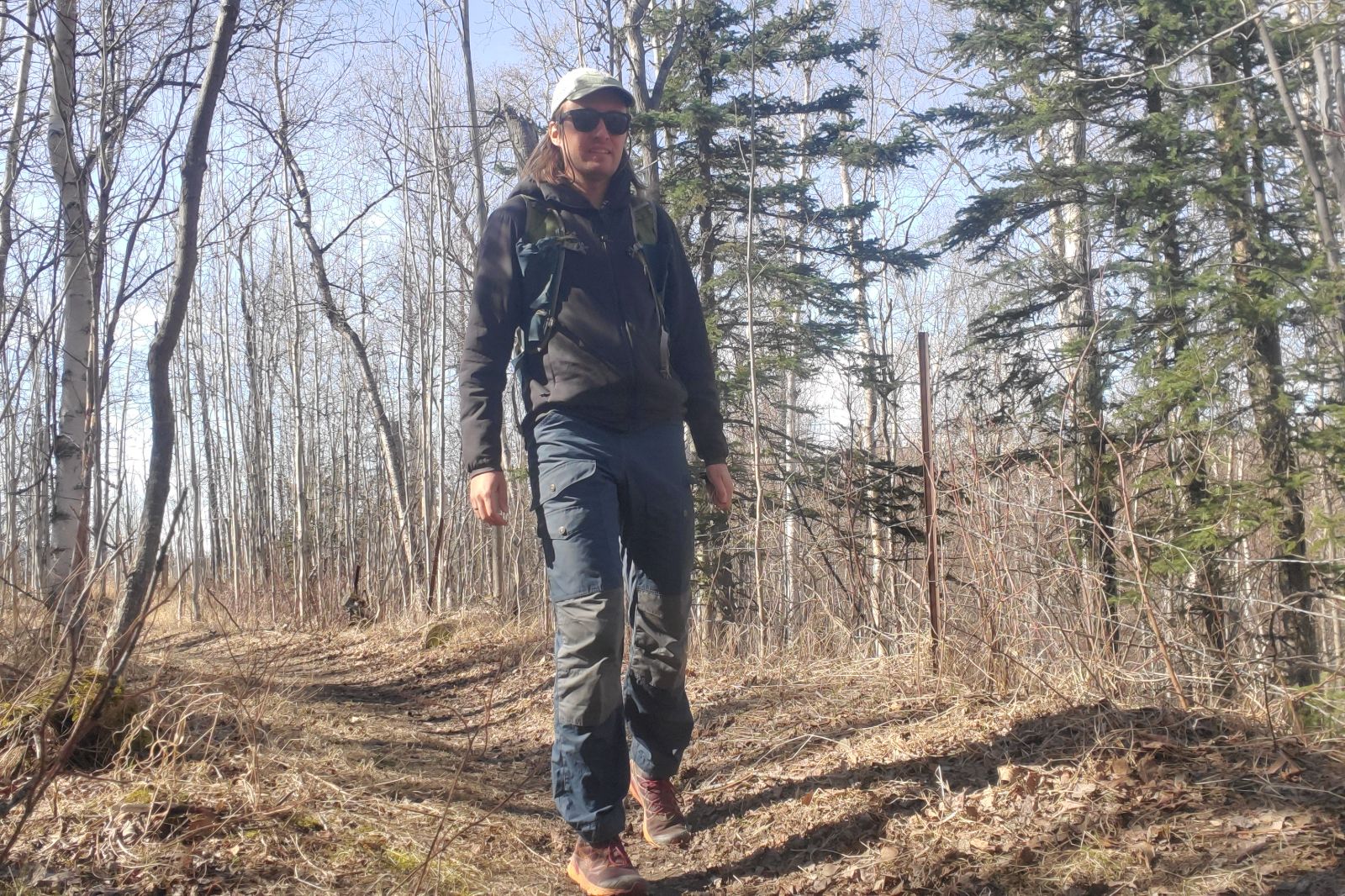 A man hikes along a trail in spring.