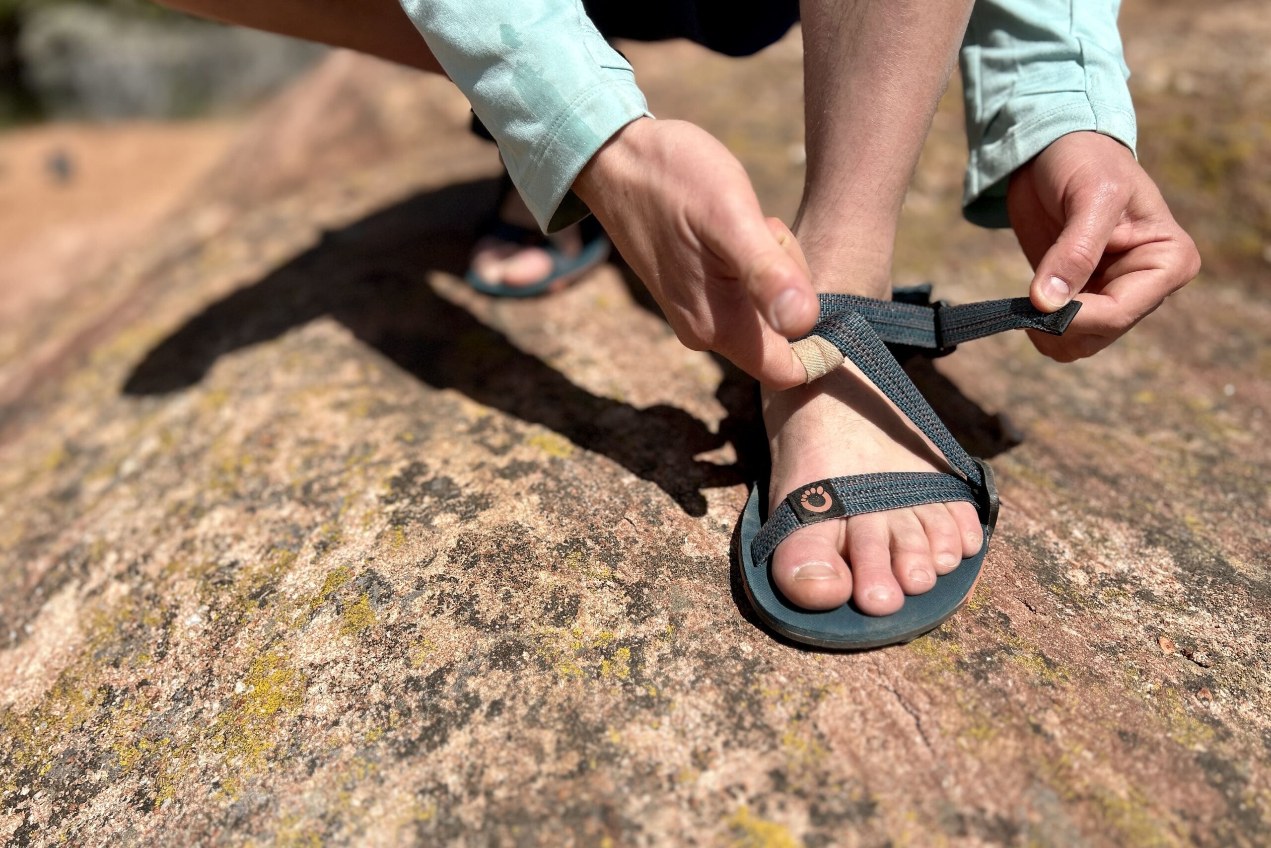 Close up image of a person adjusting a sandal.