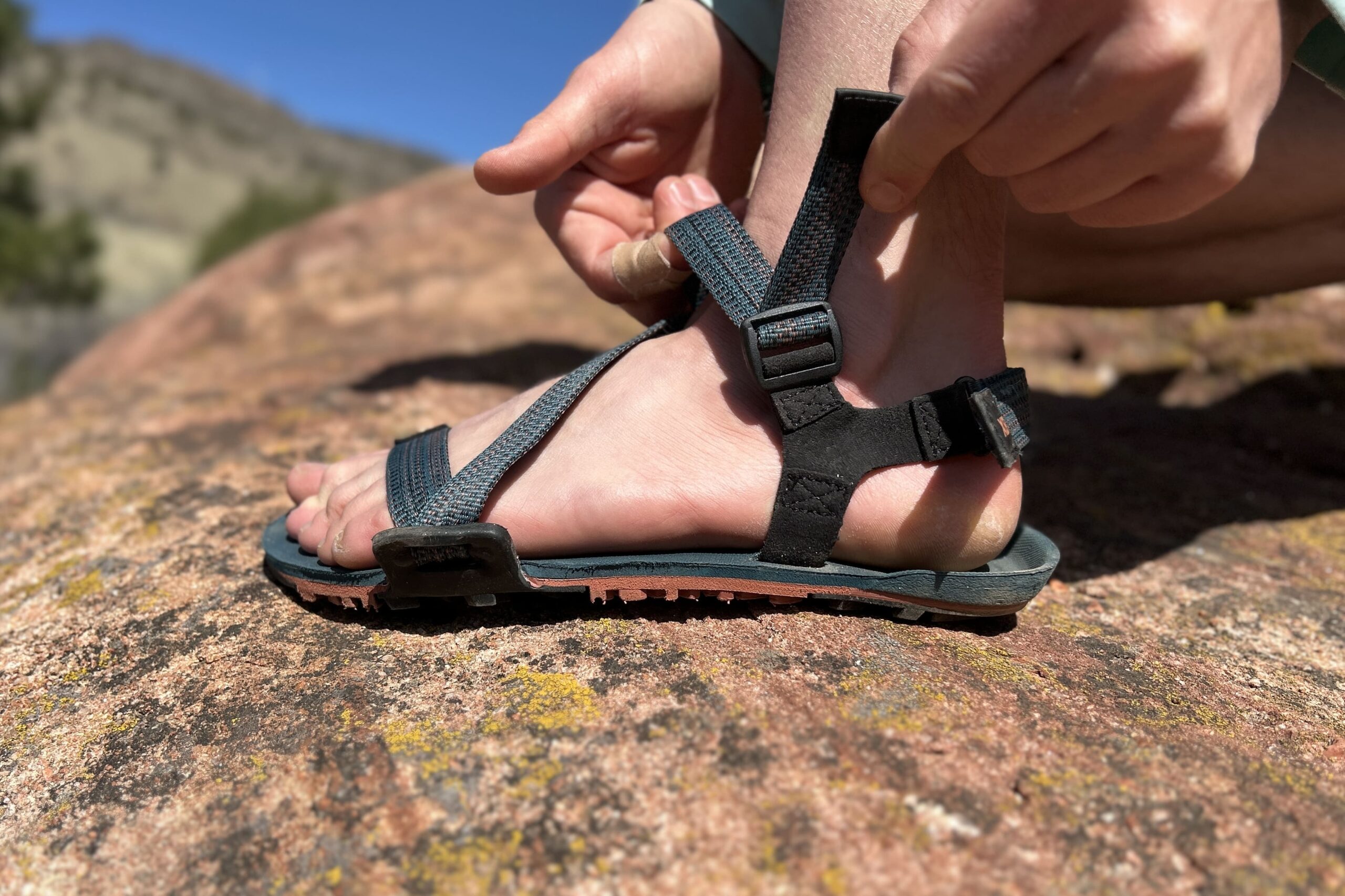 Close up image of two hands adjusting a pair of sandals