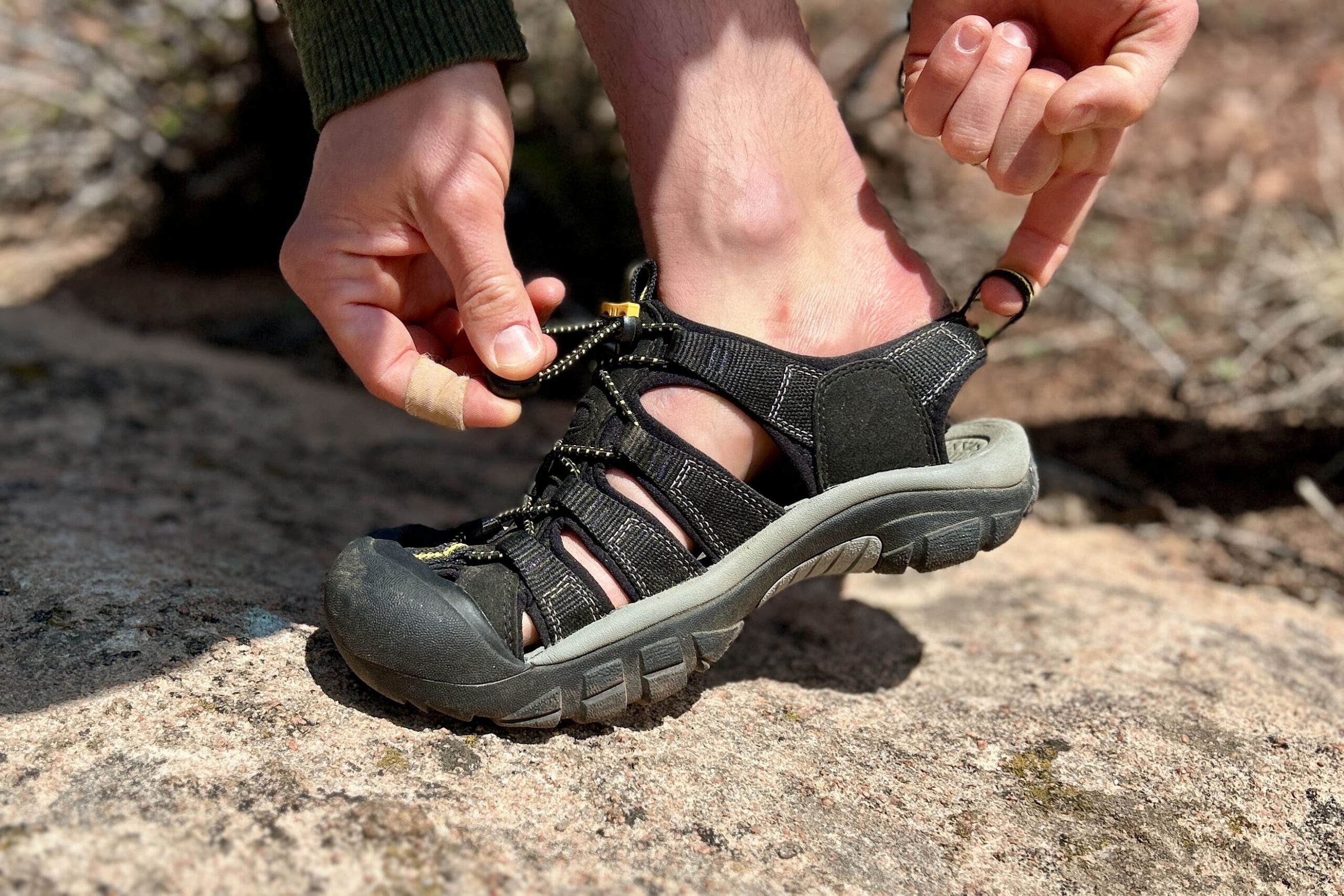 Close up image of a person adjusting a sandal.